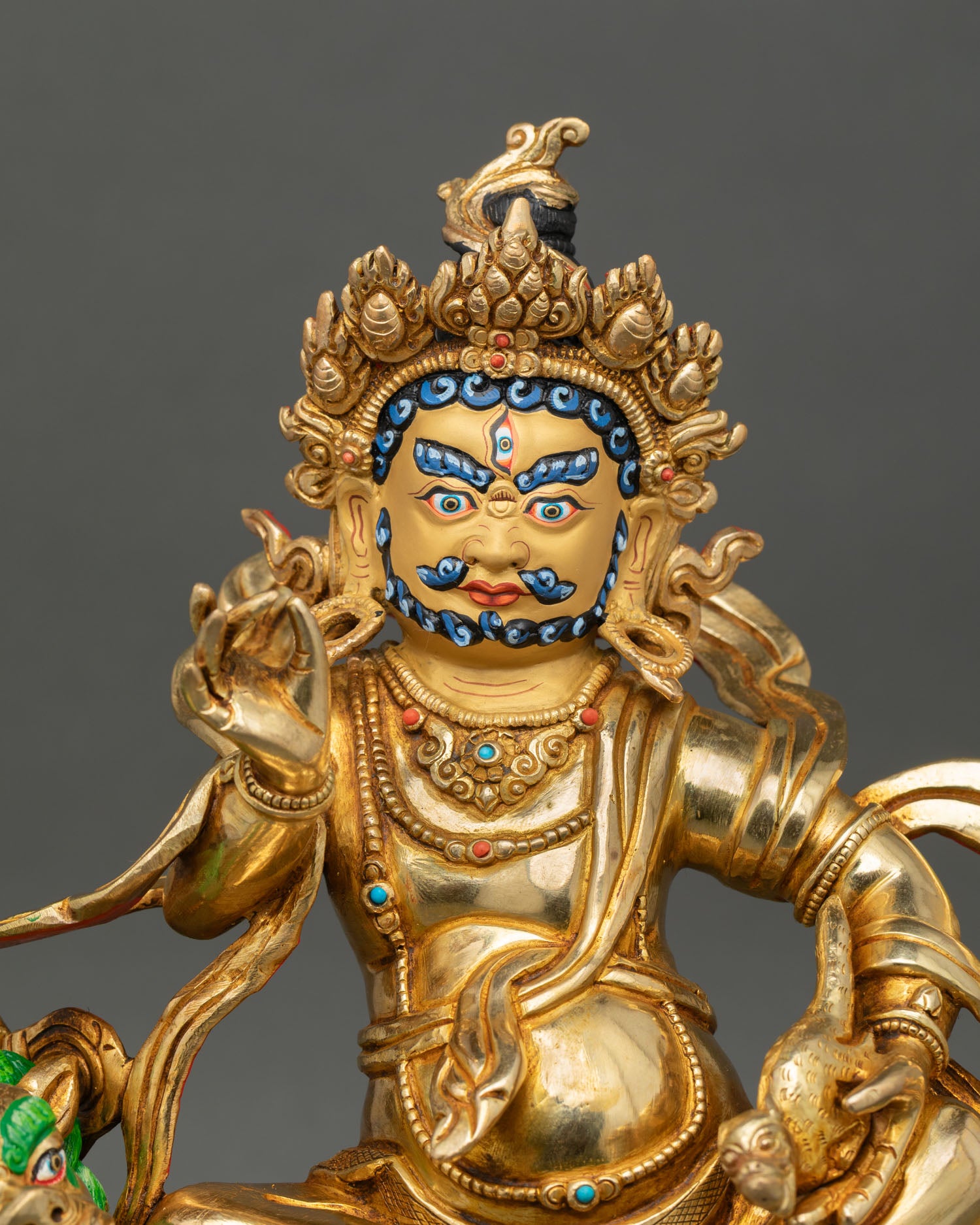 Close up of Namtoshe statue gold-painted face fierce compassionate expression Nepalese handcrafted deity