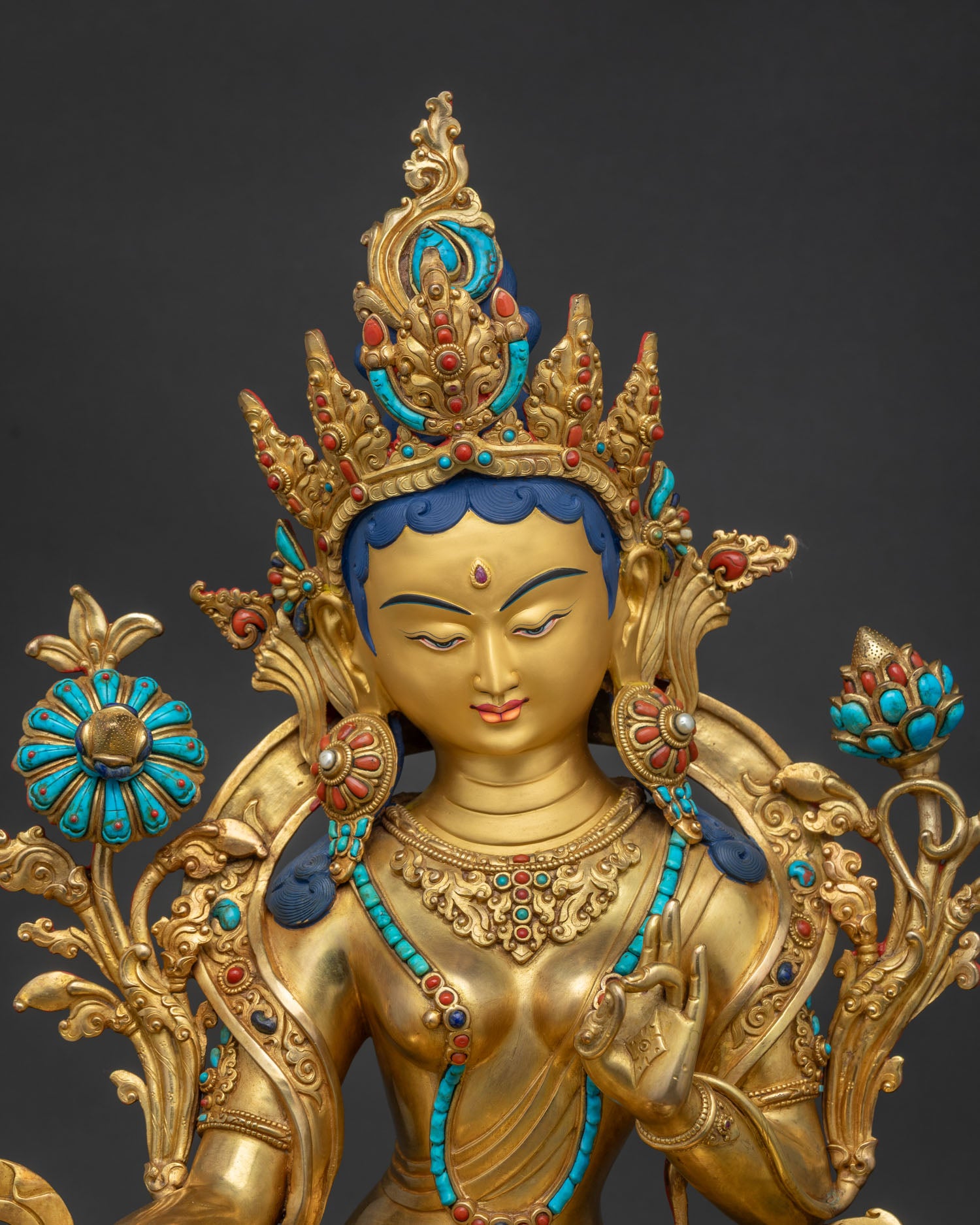 Close-up of Nepali Green Tara statue showcasing intricate gold fire-gilding and turquoise gems.