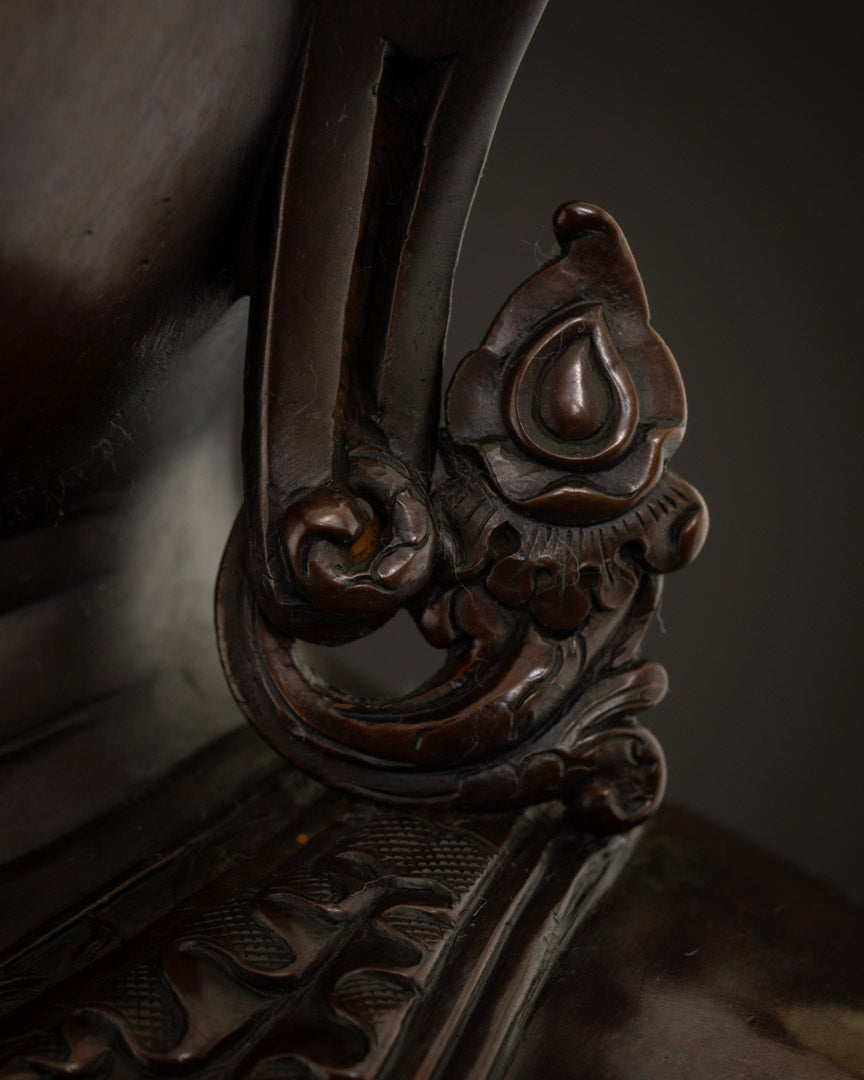 Close-up of ornate carved earring detail on copper Shakyamuni Buddha statue