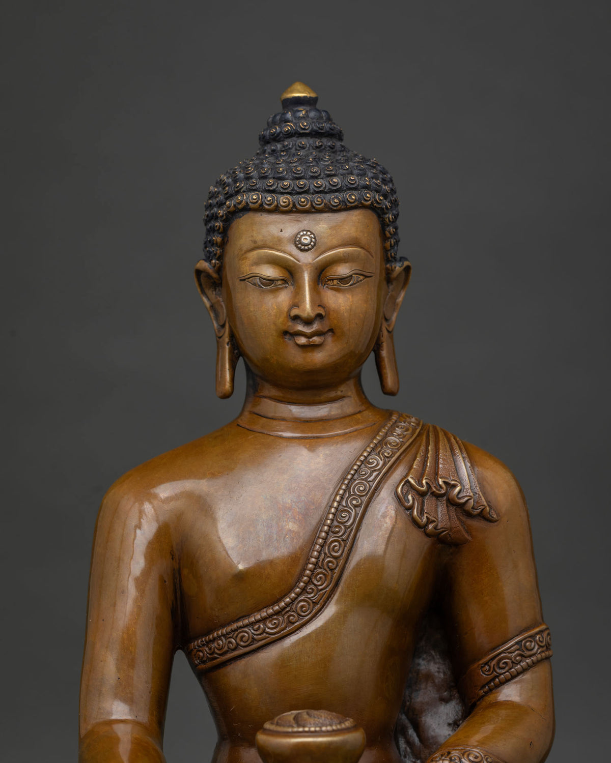close up of oxidized copper shakyamuni buddha statue with earthy patina