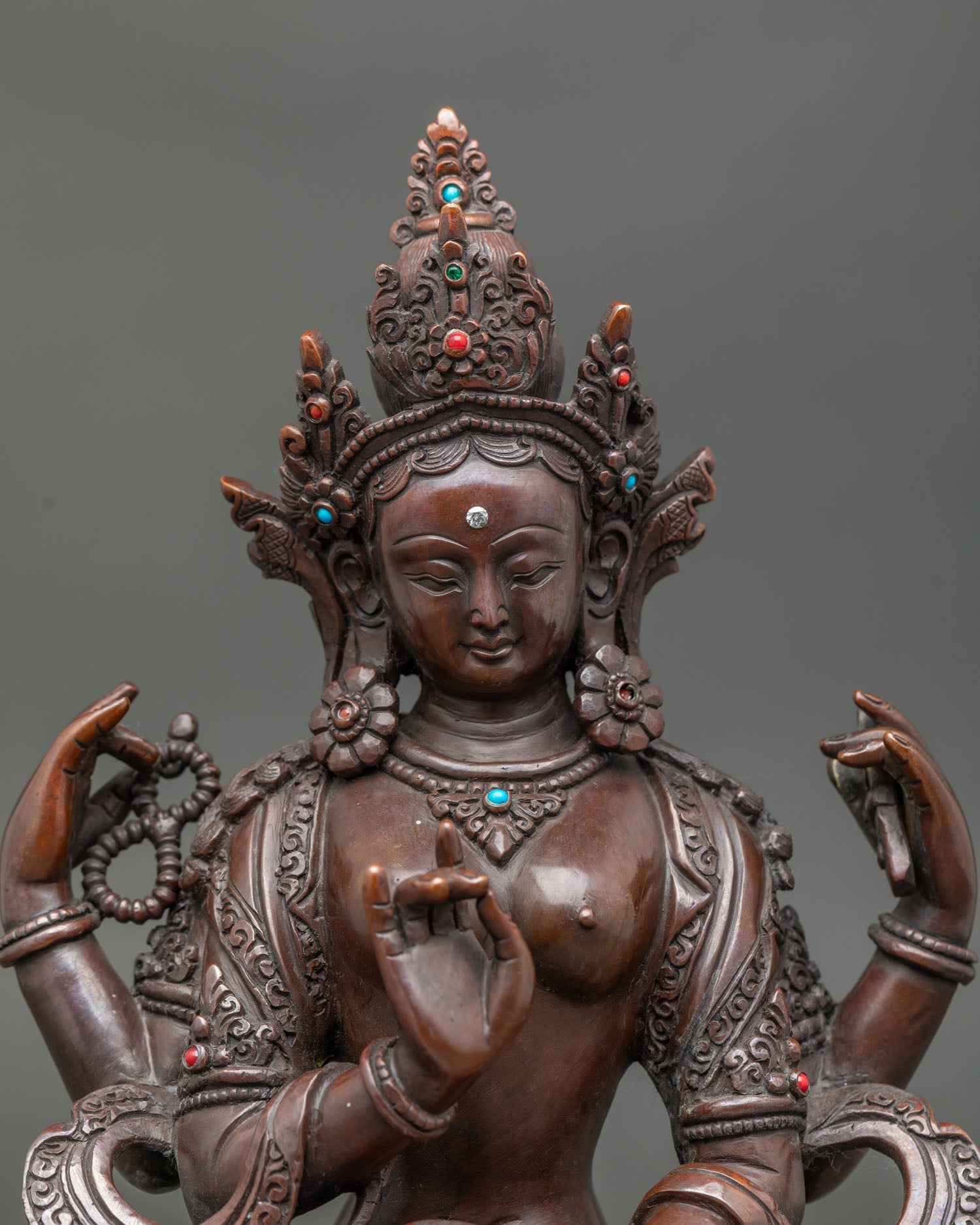close up of oxidized prajnaparamita statue showing intricate copper craftsmanship