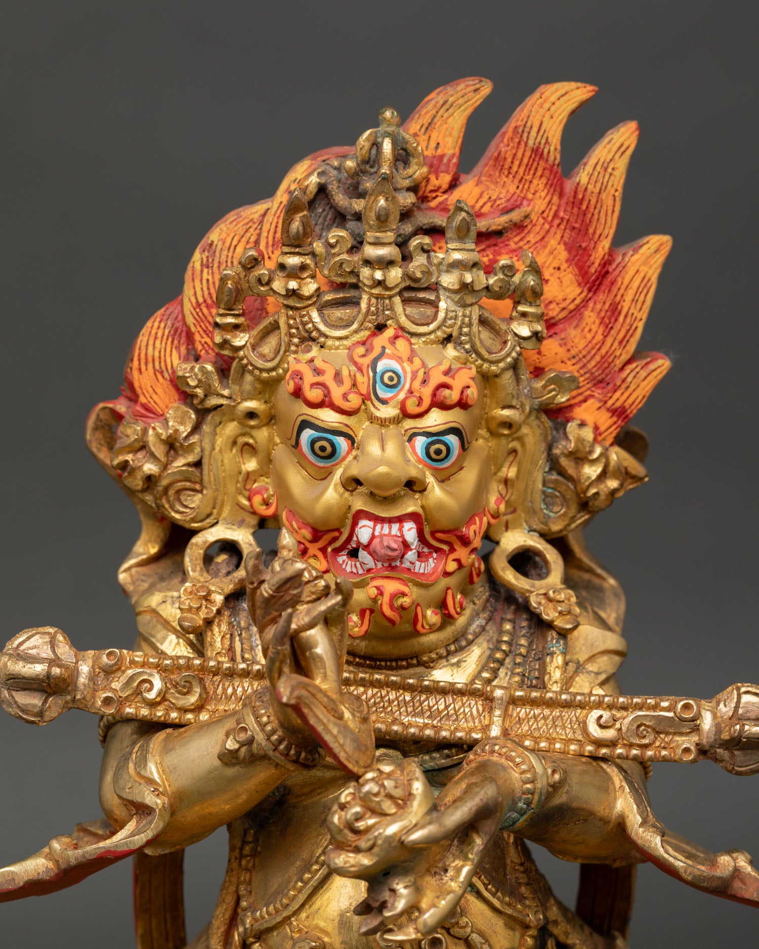 Close up of Sakya Mahakala wrathful face with gold painted details and intricate Himalayan craftsmanship