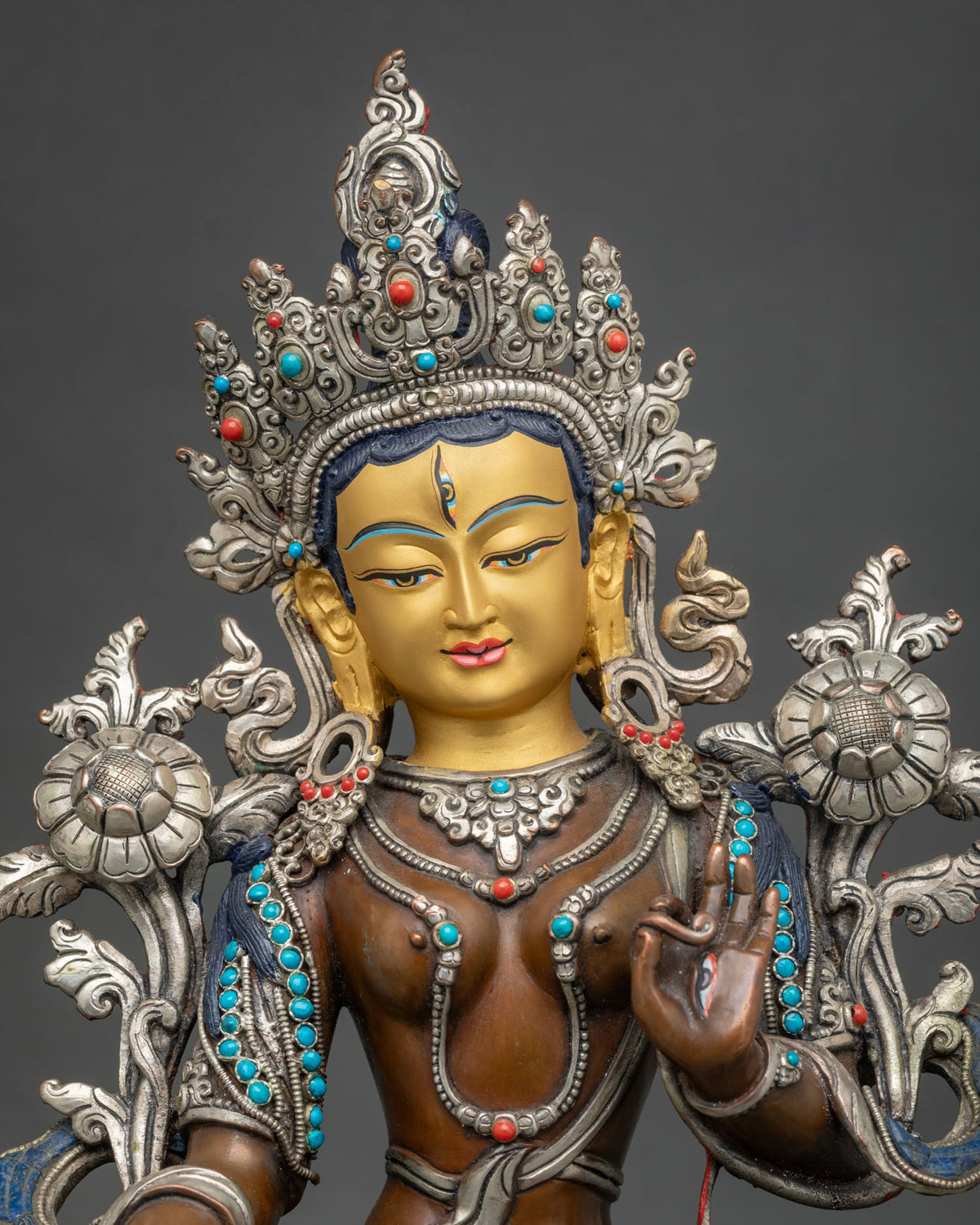 Close up of Seven-Eyed White Tara Statue with silver-plated crown, turquoise and coral jewelry