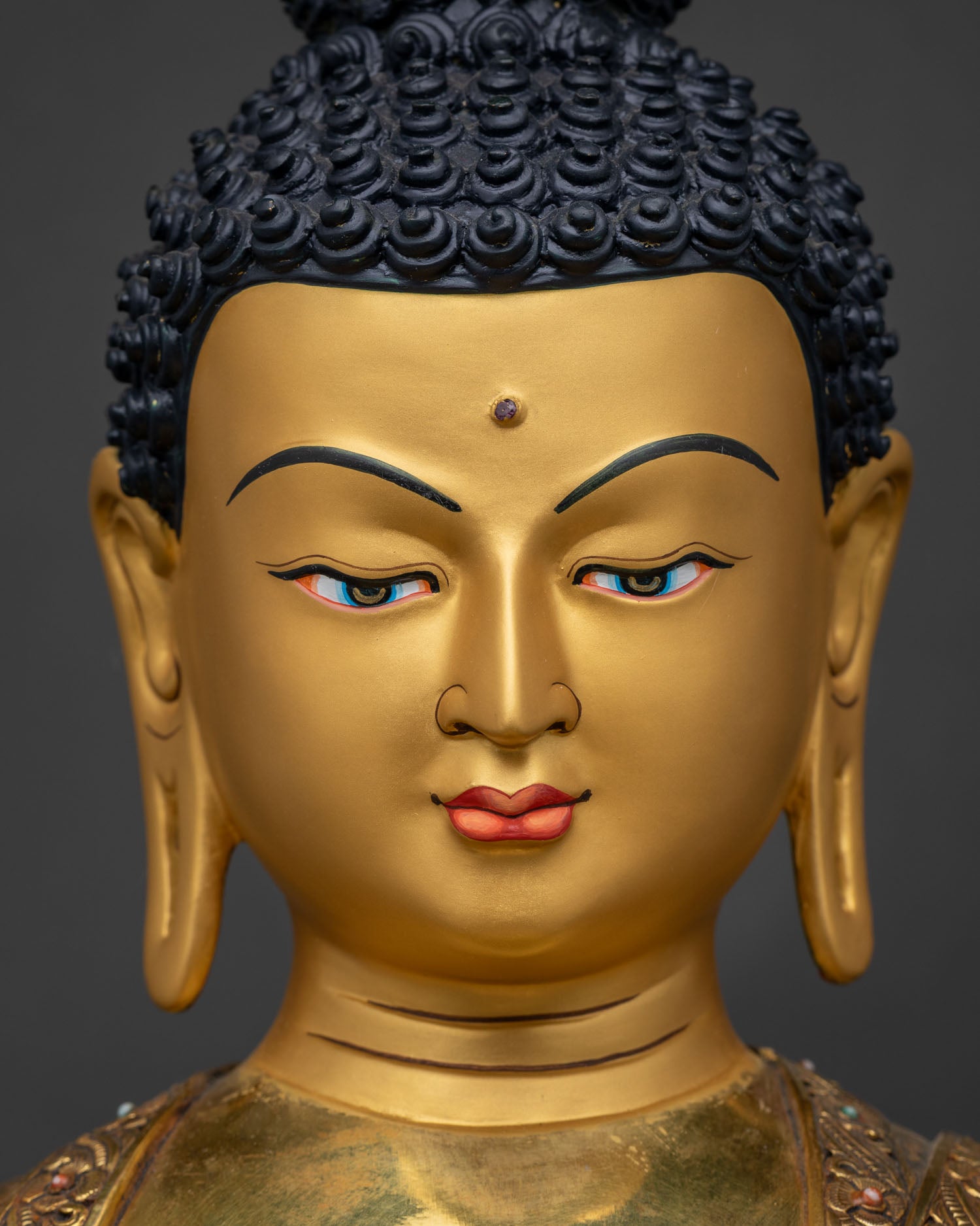 Close up of Shakyamuni Buddha statue face with 24K gold painted expression