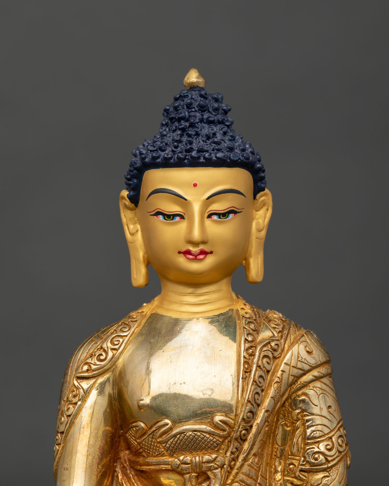 Close-up of Shakyamuni Buddha statue showing Bhumisparsha Mudra and gold-gilded details