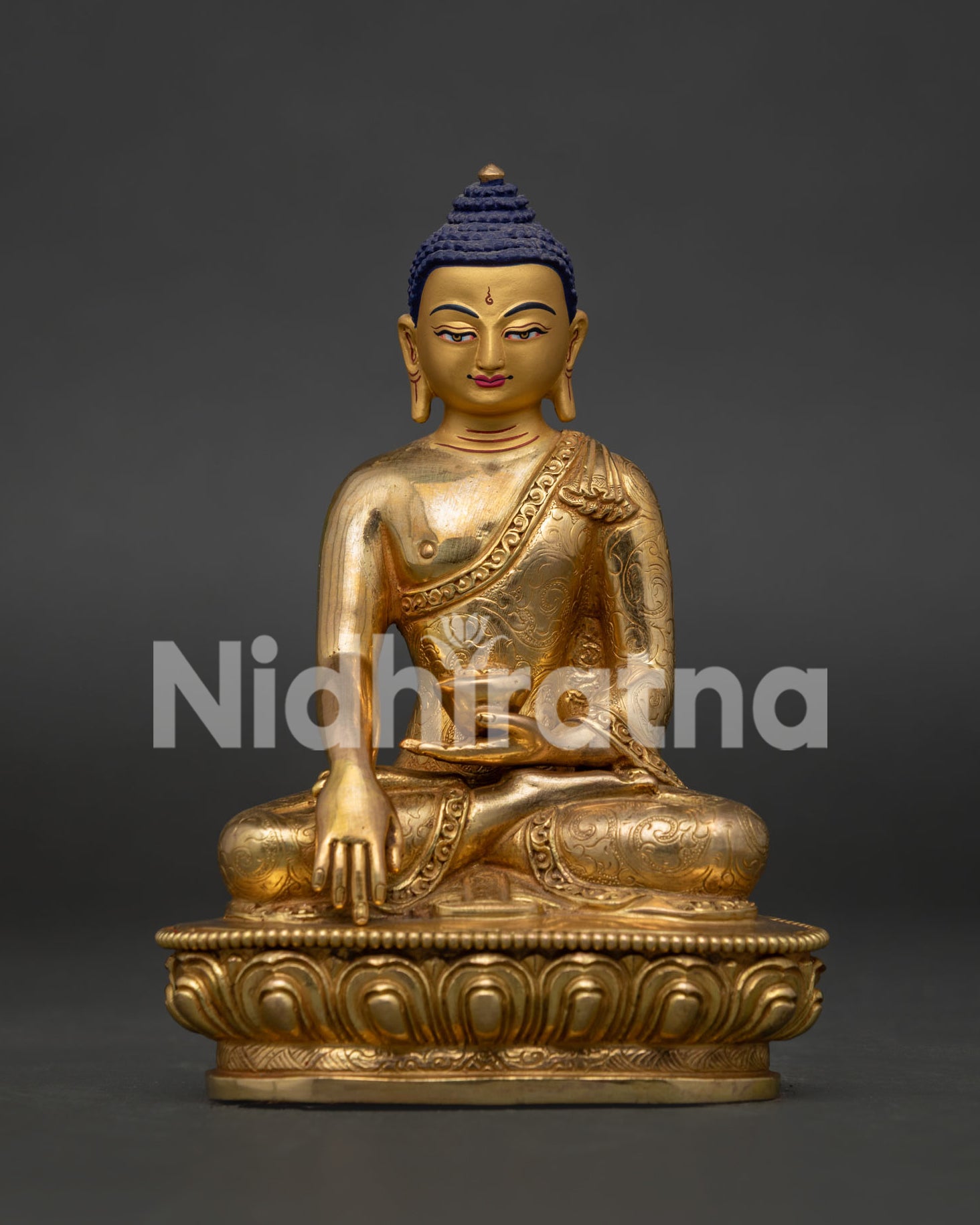 Close up of Shakyamuni Buddha Statue with gold gilded finish serene face and intricate floral motifs