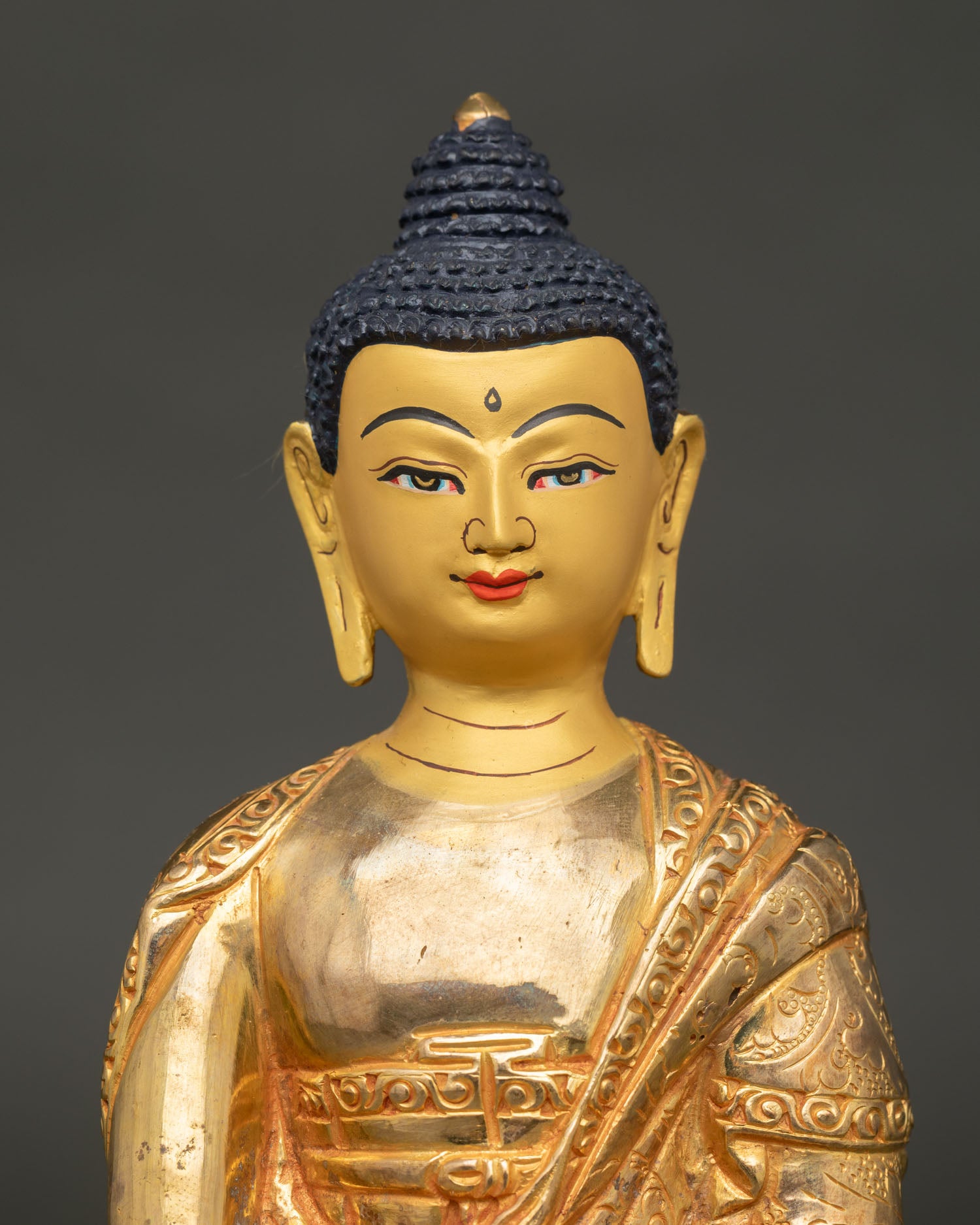 Close Up of Shakyamuni Buddha Statue with Gold Painted Face and Bhumisparsha Mudra.