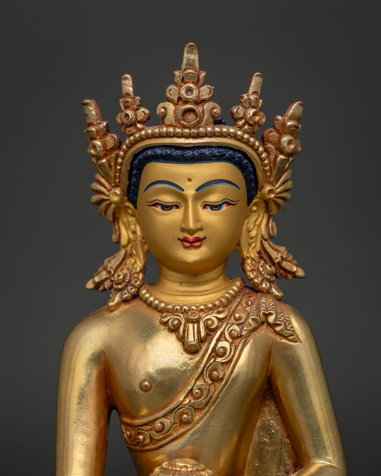 Close Up of Shakyamuni Buddha Statue with Gold Painted Face and Repoussé Details