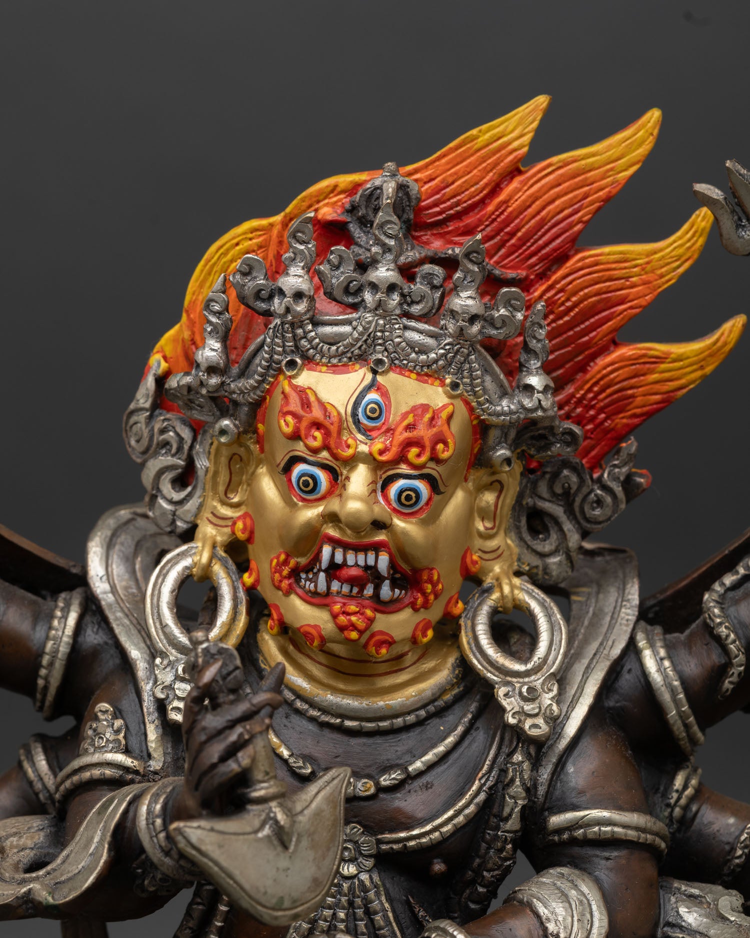 Close-up of Six-Armed Mahakala face with three eyes, flaming hair, and gold-accented wrathful expression, Himalayan Buddhist sculpture