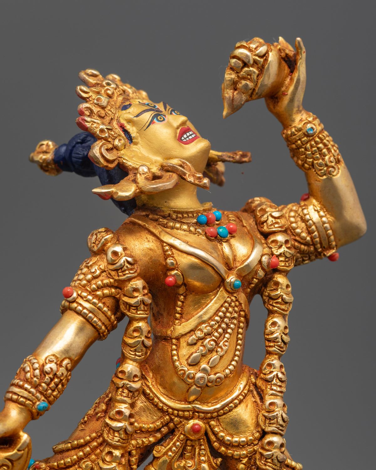 Close-up of the gold-painted Vajrayogini statue featuring intricate ornaments, semi-precious stones, and a flaming halo