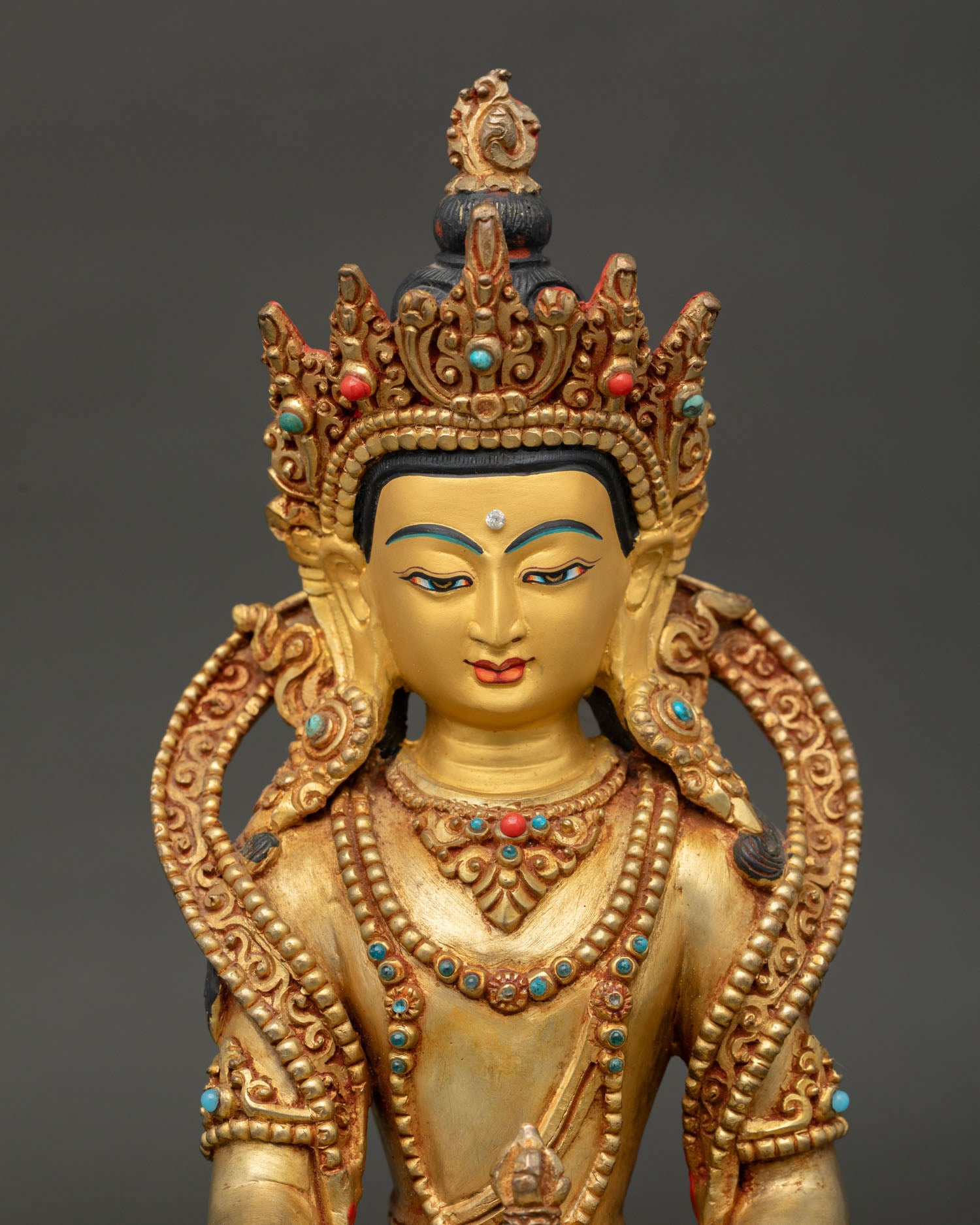 Close up of the Mitrugpa Buddha Statue highlighting the gold painted face and intricate Newari craftsmanship.
