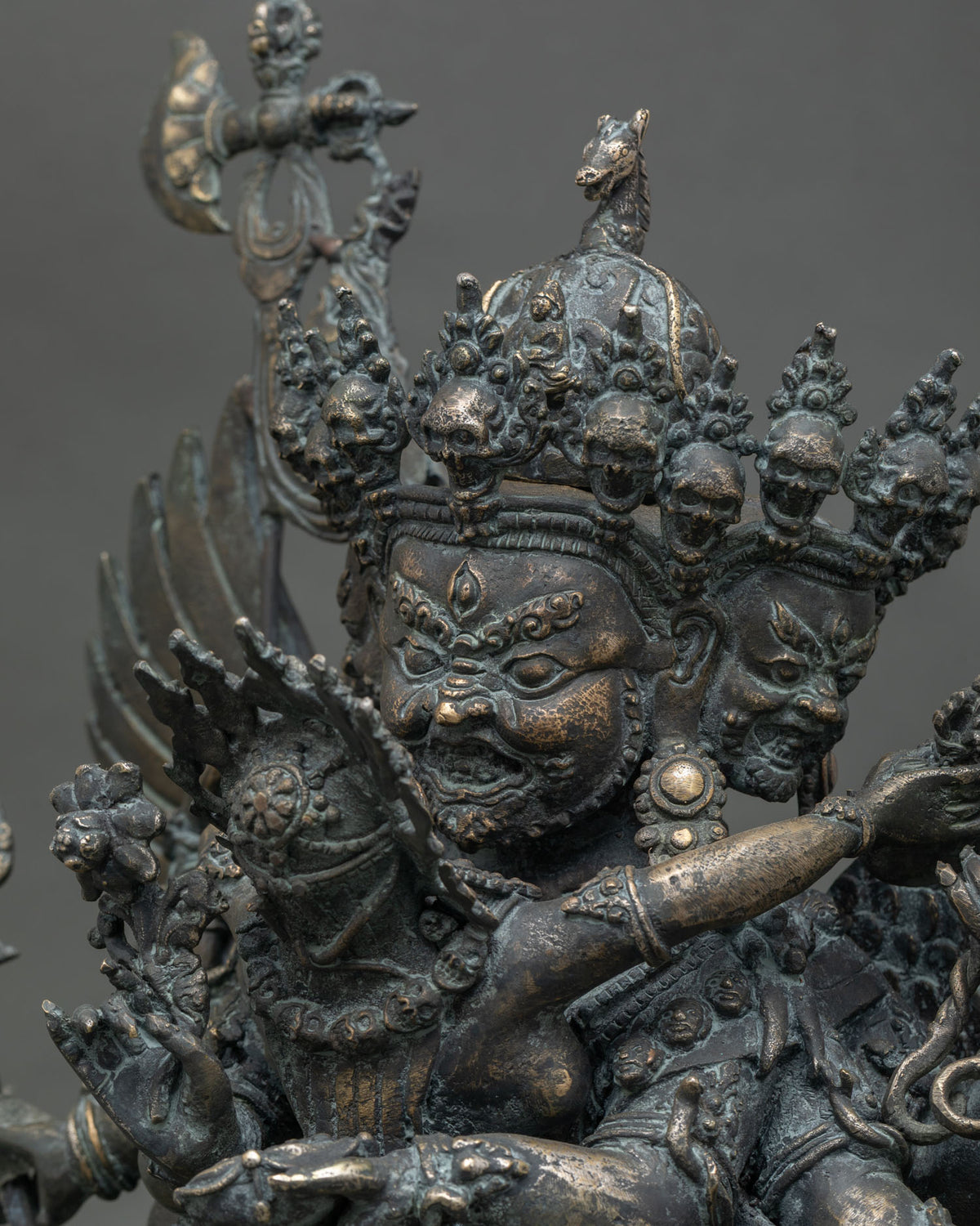 Close-up of three wrathful faces on handmade Hayagriva bronze statue with fine detailing