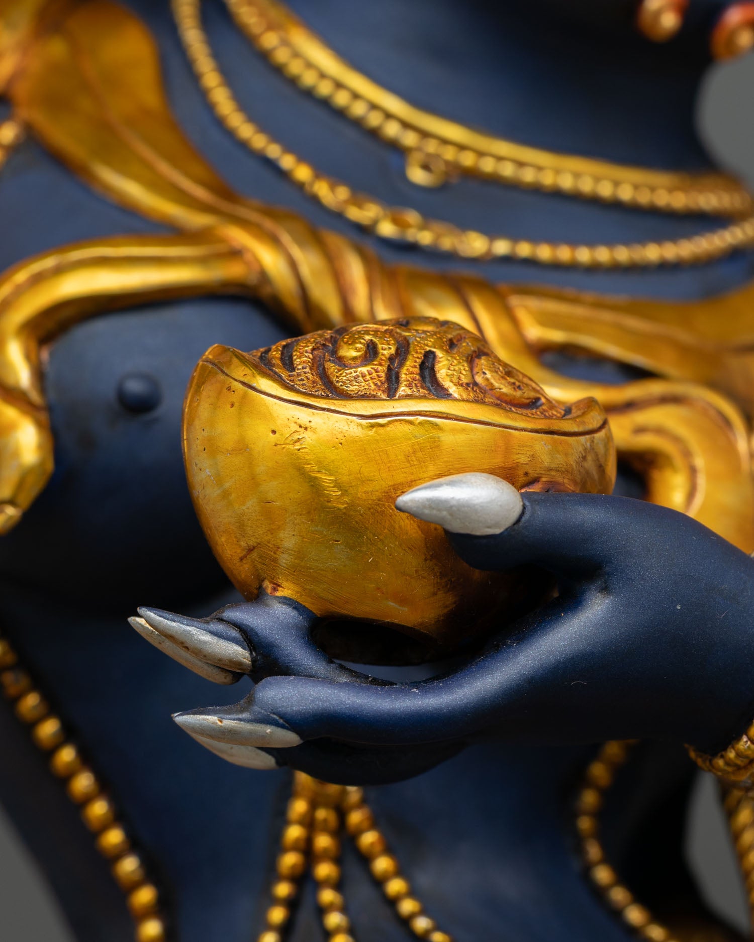 Close-up of Troma Nagmo Statue holding a skull cup symbolizing wisdom and transformation.