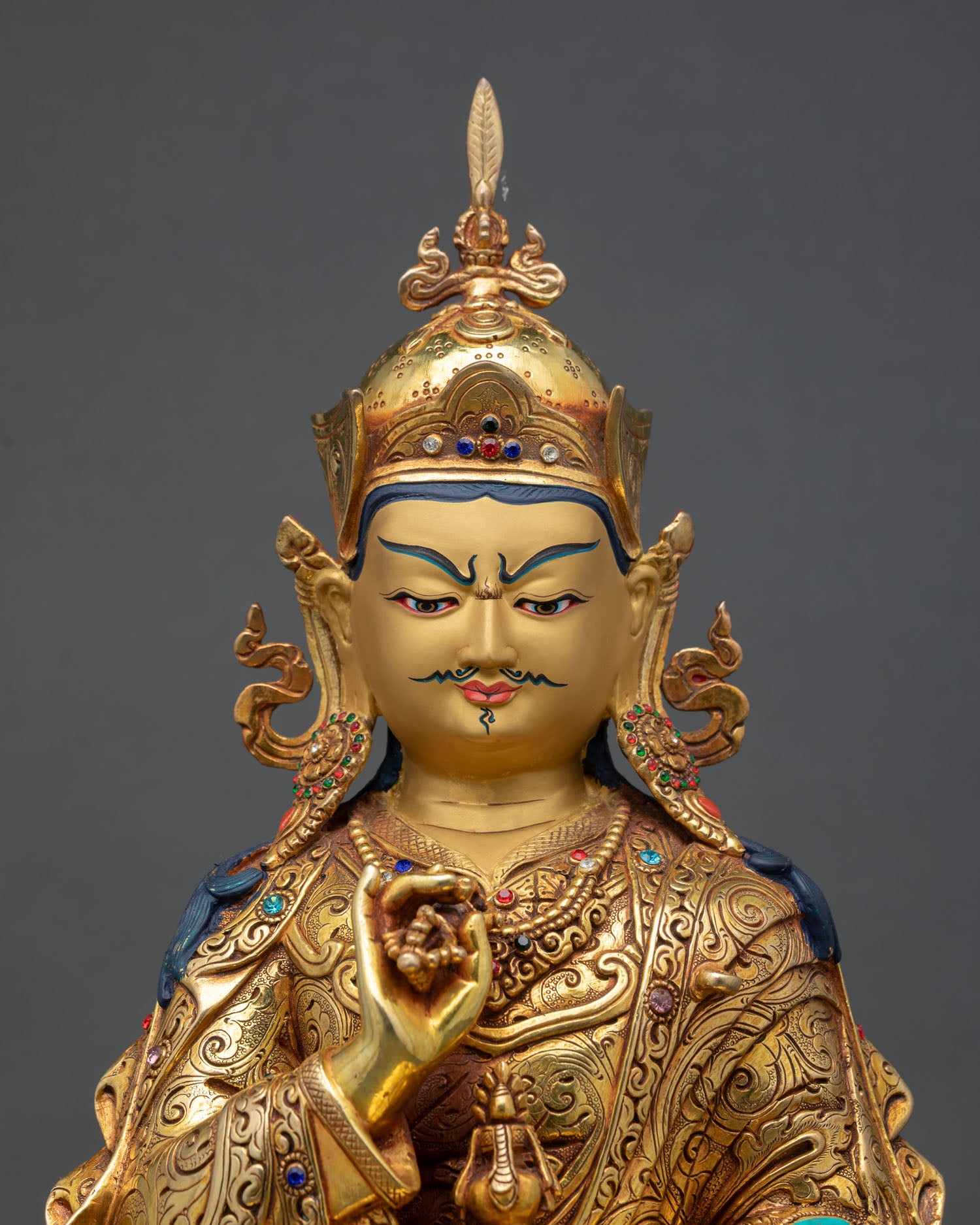 close up of tsokye dorje statue with repoussé details and turquoise coral inlays