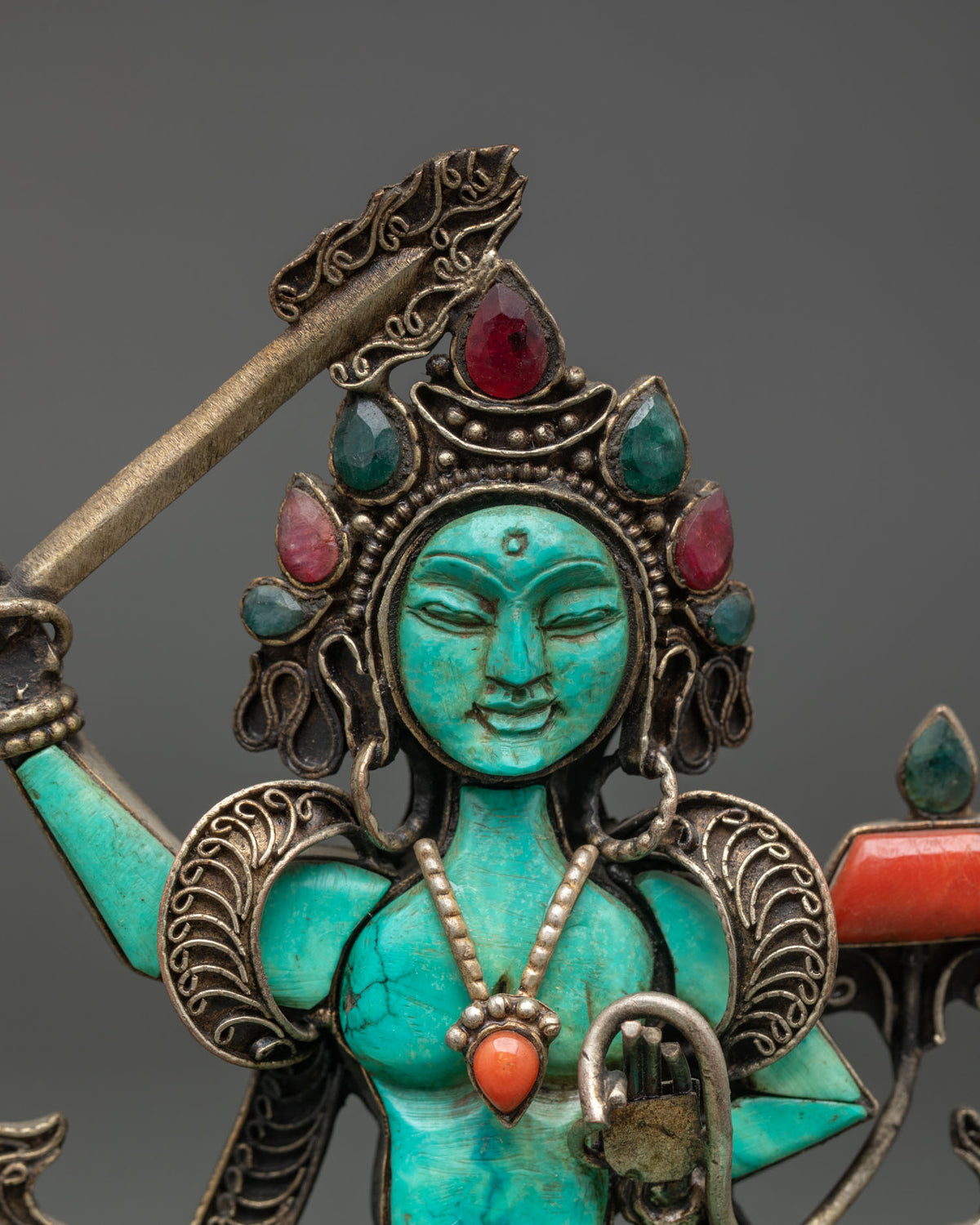 Close-up of turquoise Manjushri face and gemstone crown, handcrafted Nepalese Buddhist art