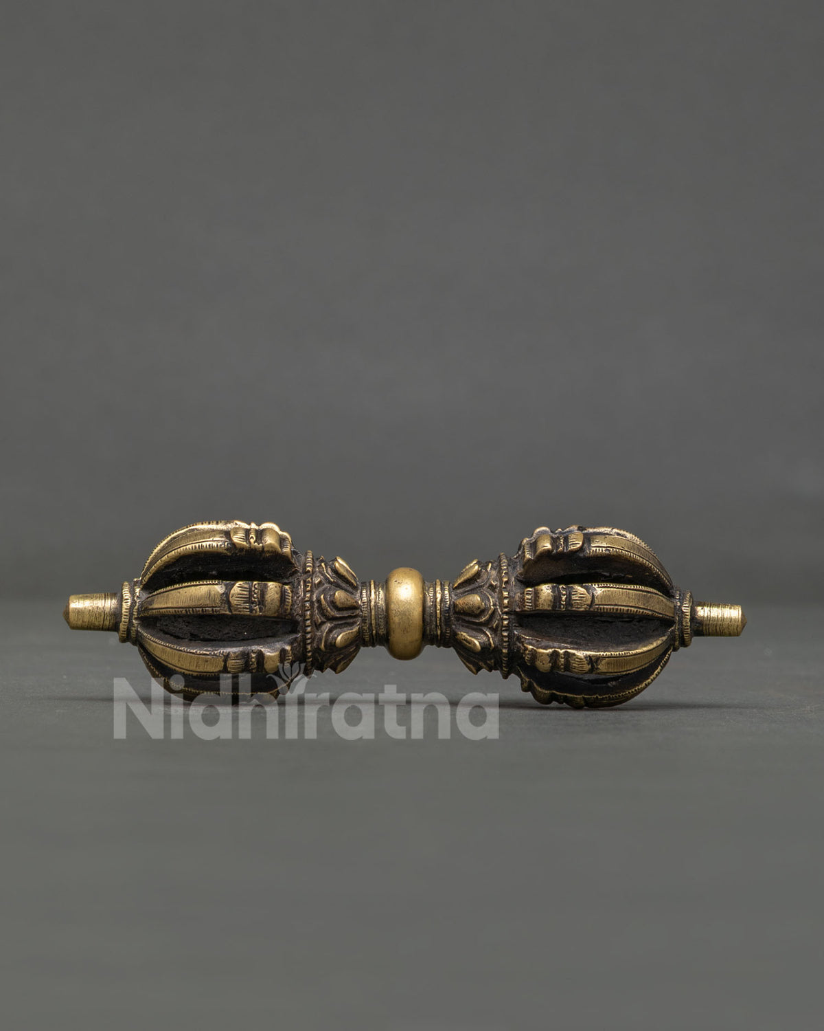 Close up of Vajra with intricate carvings and buddhist mantra motifs.