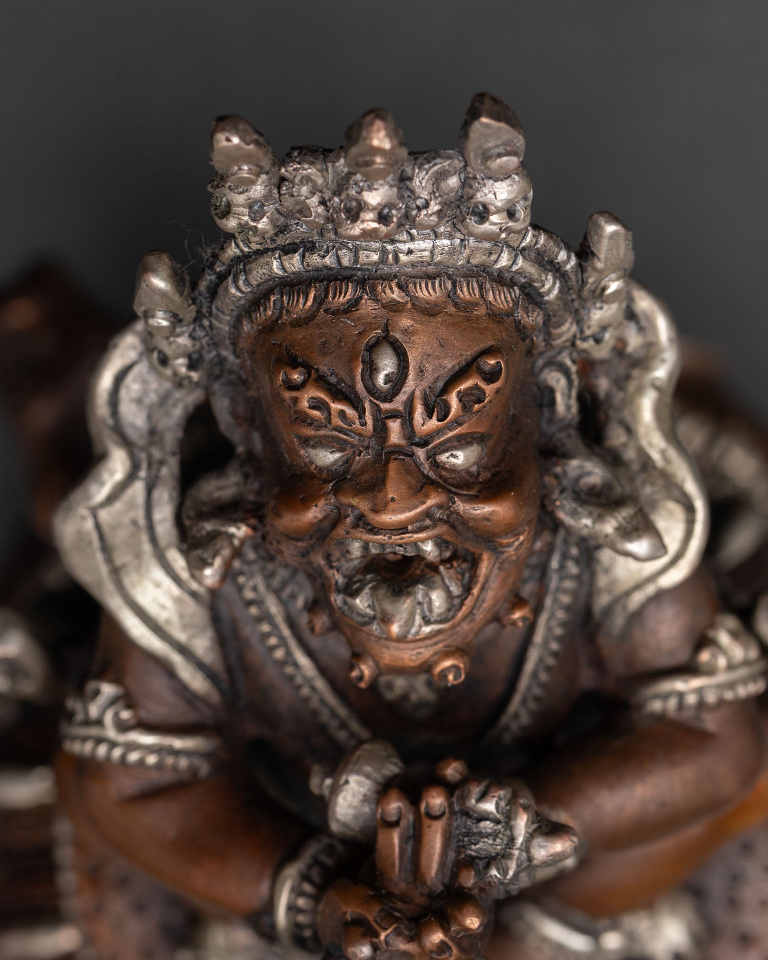 close up of vajradaka statue with wrathful expression and intricate jewelry