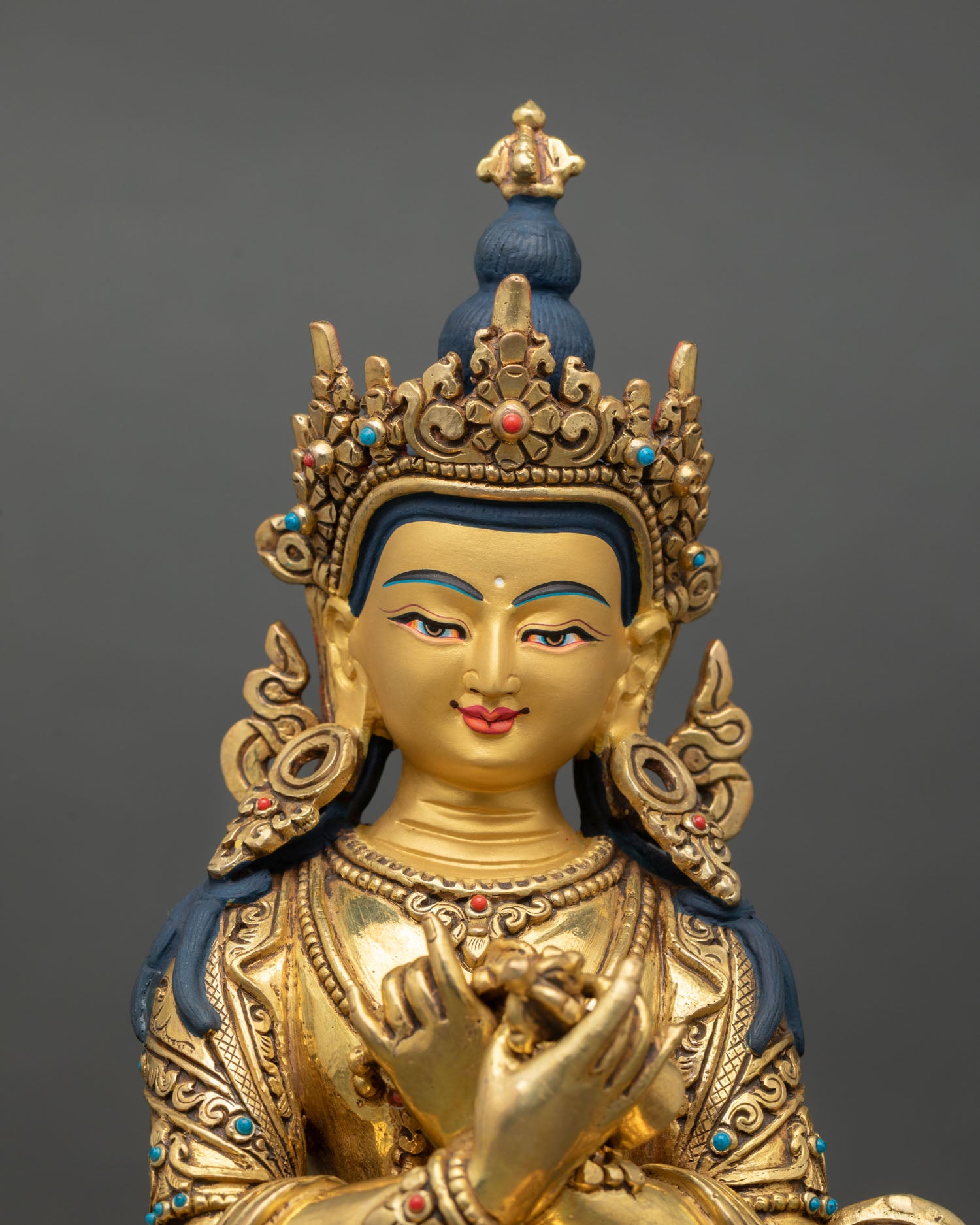 Close up of Vajradhara face with gold painted detailing and intricate Himalayan craftsmanship, Tibetan Buddhist art