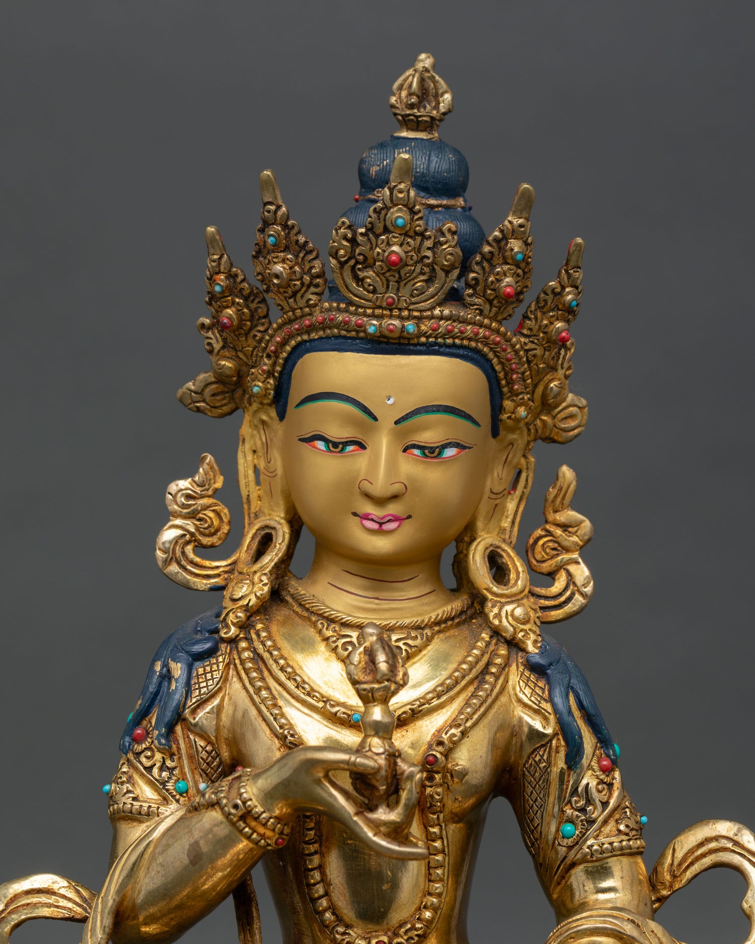 Close up of Vajrasattva face with gold painted details five jeweled crown and serene expression