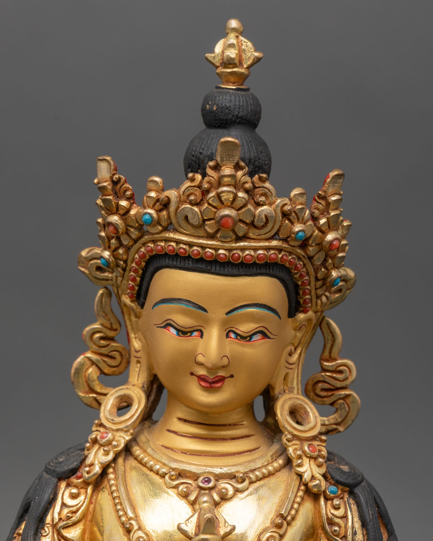 Close up of Vajrasattva’s gold-painted face, jeweled crown, flaming aureole, and semi-precious stones.