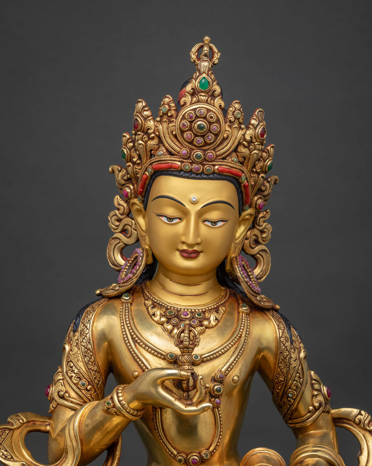 Close up of Vajrasattva Statue face and jeweled crown, gold gilded Buddhist deity