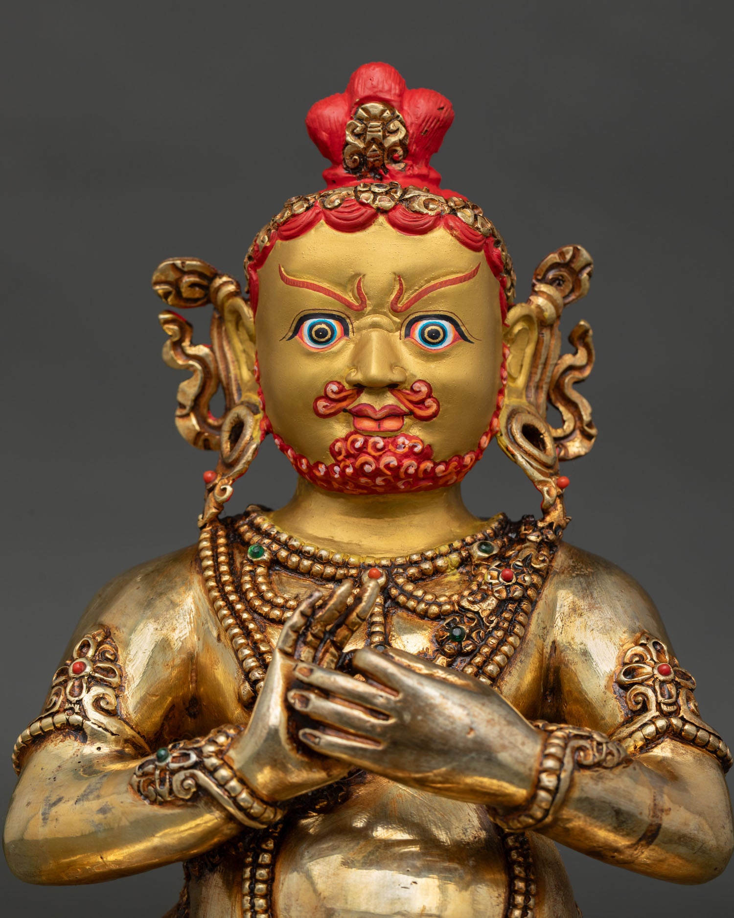 Close up of Virupa statue showing gold painted face and intricate Himalayan Buddhist craftsmanship