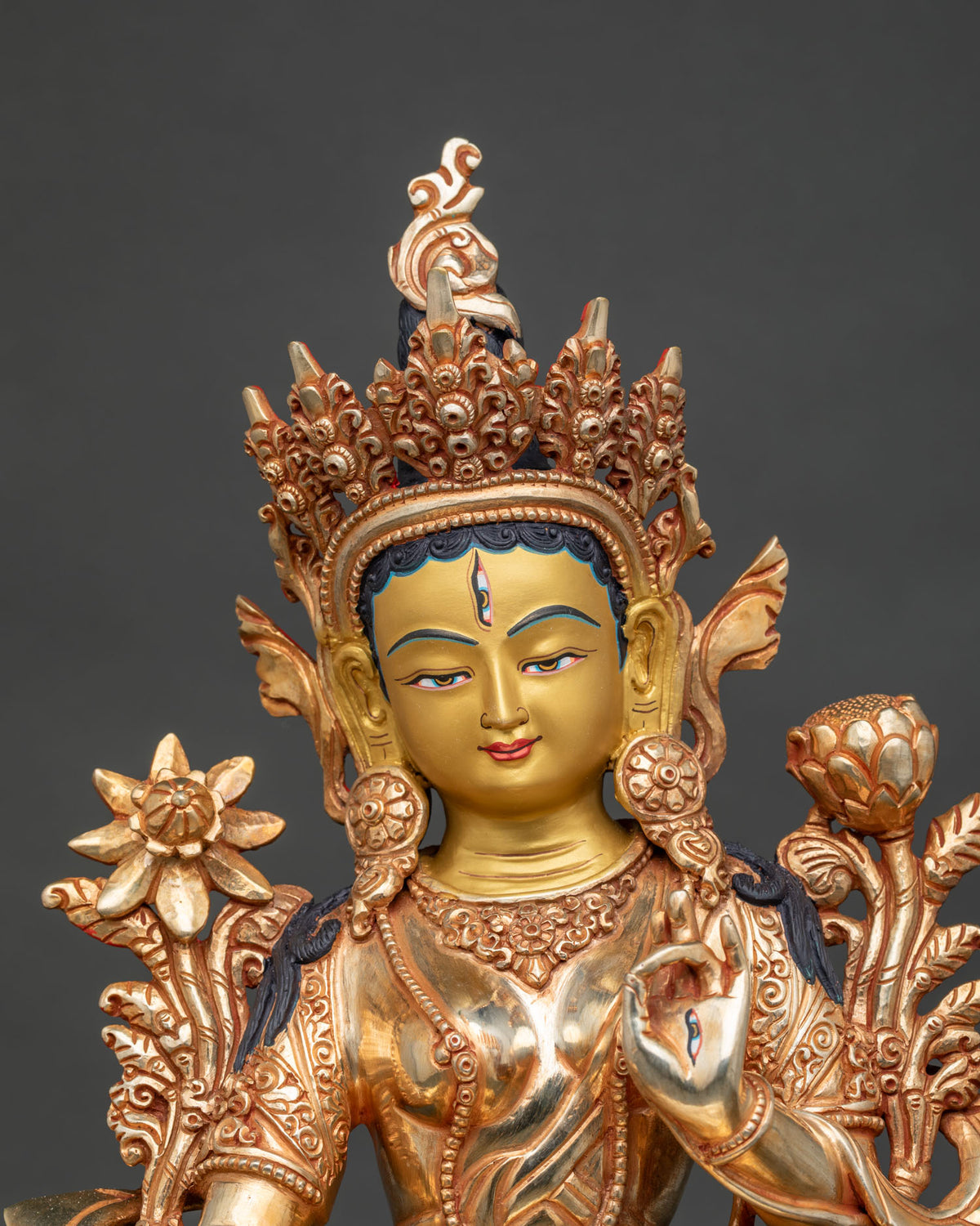 Close up of White Tara statue showing serene 24K gold painted face jeweled crown and detailed Buddhist craftsmanship.