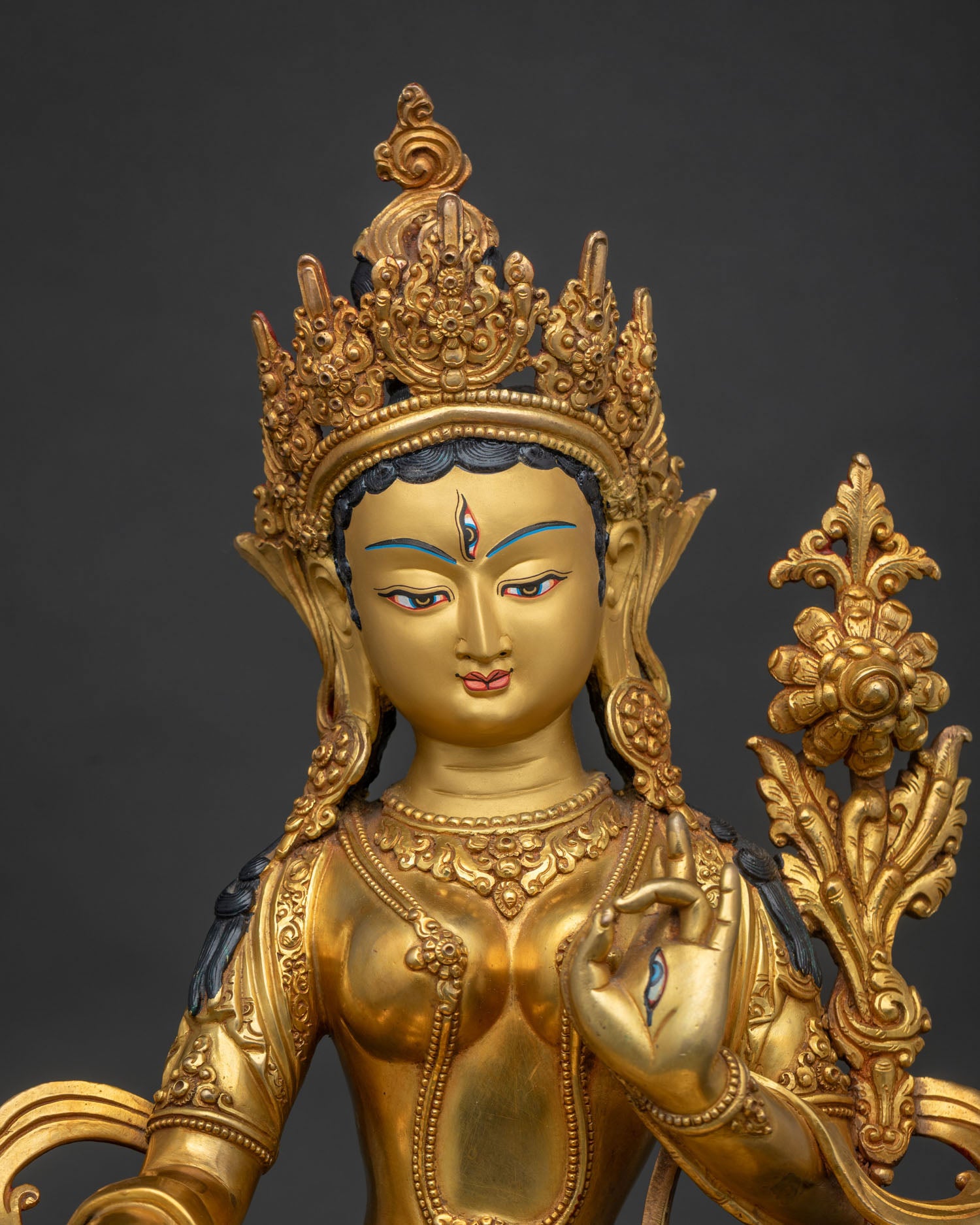 Close-up of White Tara statue with jeweled crown and gold fire-gilded finish