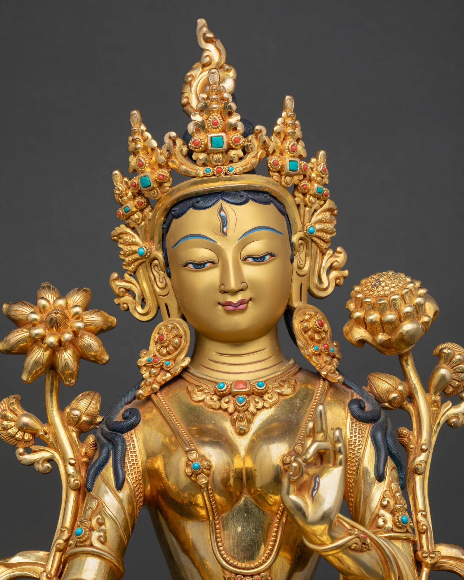 close up of white tara statue with repoussé details and semi precious stone inlay