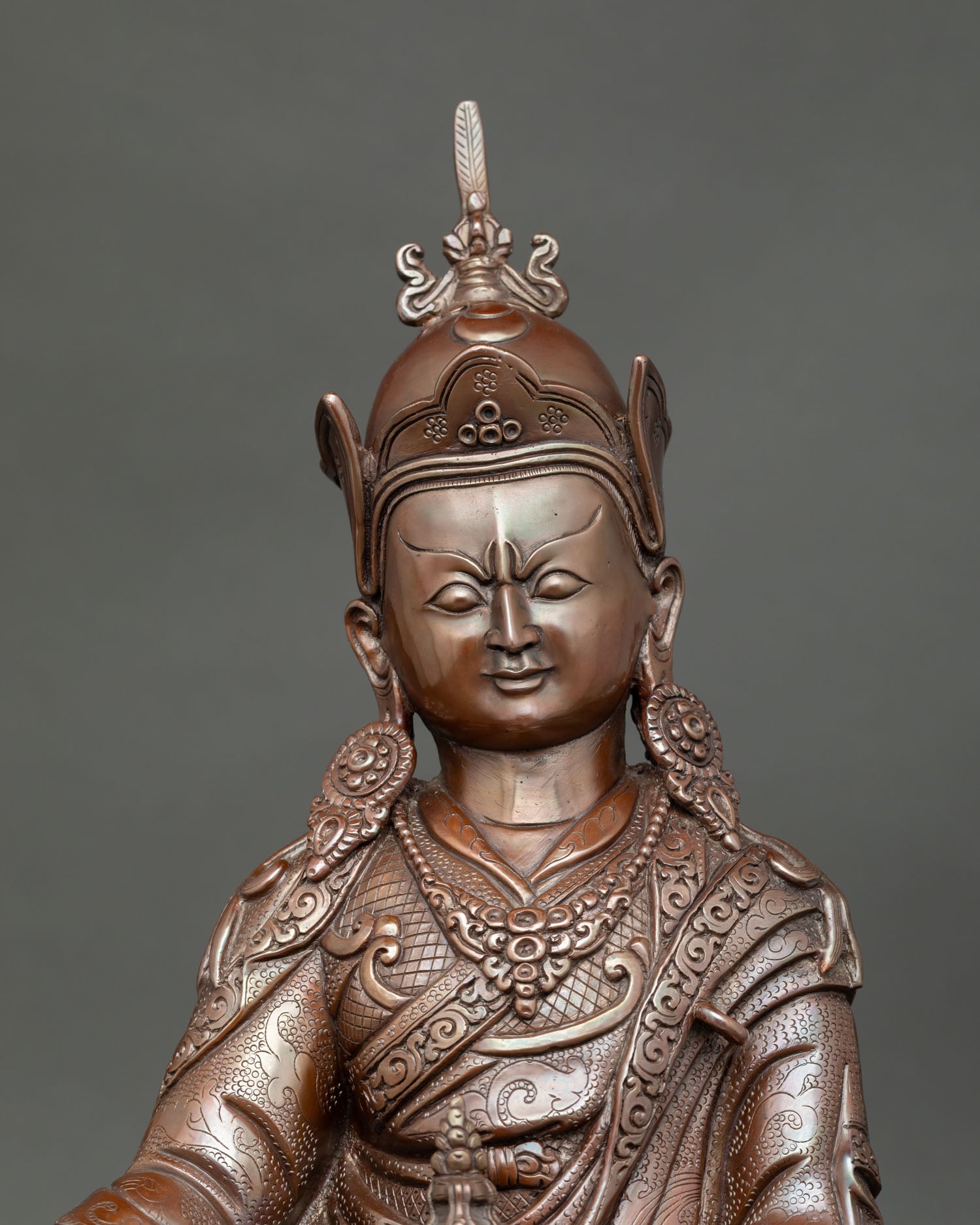 Close up Padmasambhava sculpture showing detailed facial expression and intricate Himalayan metal craftsmanship in oxidized finish