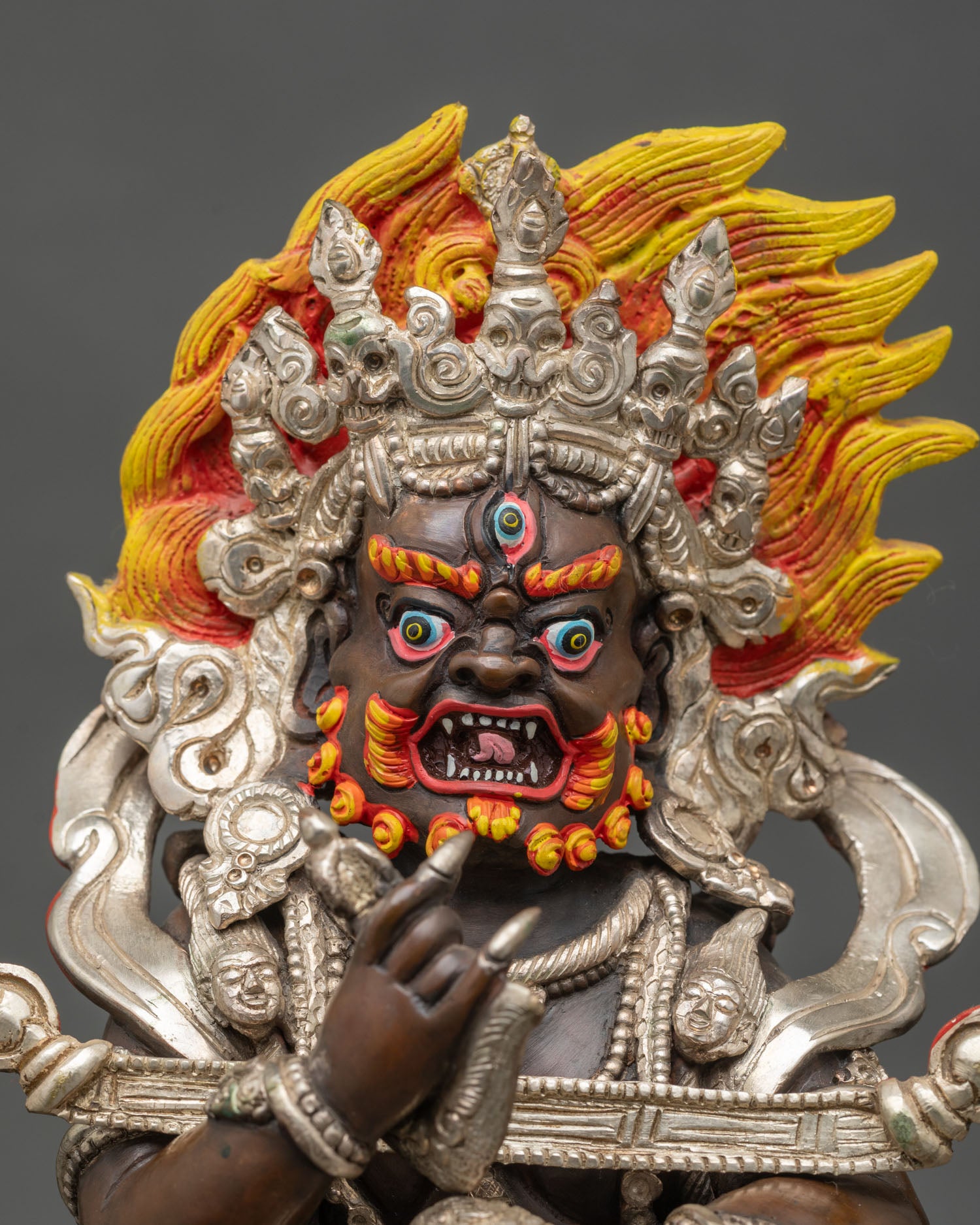 Close up of Sakya Mahakala statue showing five-skull crown, serpent garland, and tiger-skin ornaments