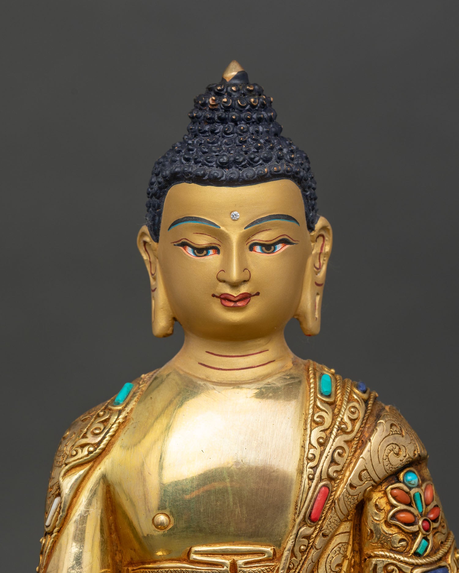 Close up Shakyamuni Buddha face detail gold gilded accents, Himalayan Buddhist statue