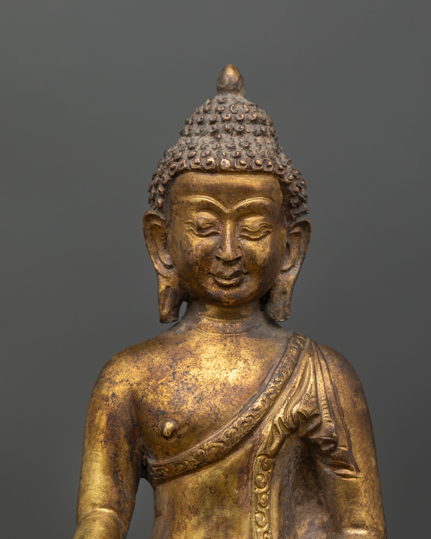 Close up Shakyamuni Buddha face detail serene expression hand crafted lost wax casting, spiritual enlightenment statue