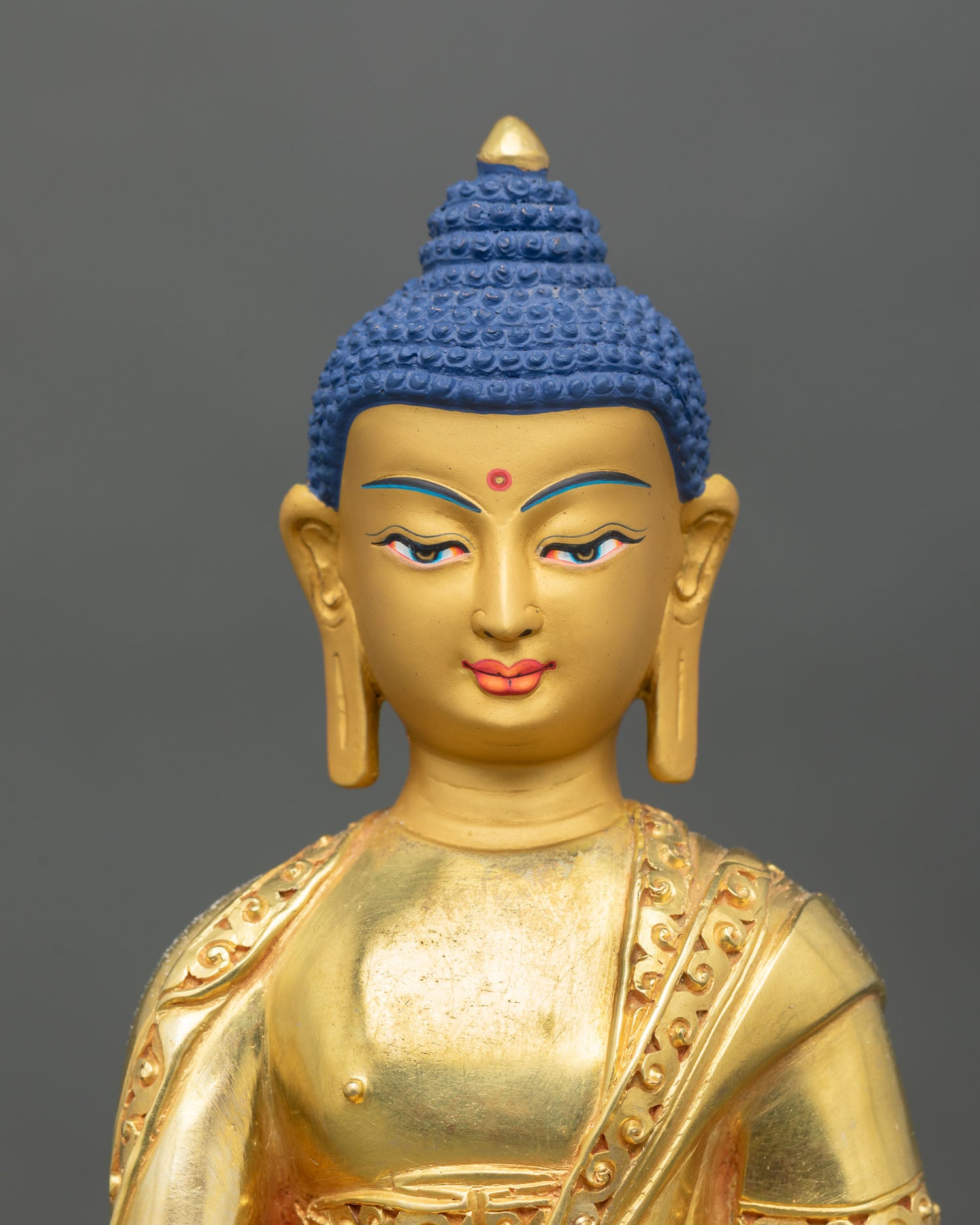 Close up Shakyamuni Buddha face gold mineral pigment hand painted serene expression Newari artisan Himalayan Buddhist sacred art detail