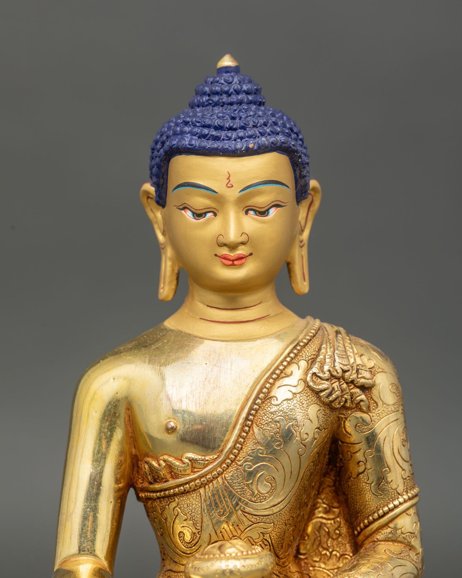 Close up Shakyamuni Buddha face gold-painted serene expression with intricate floral motifs