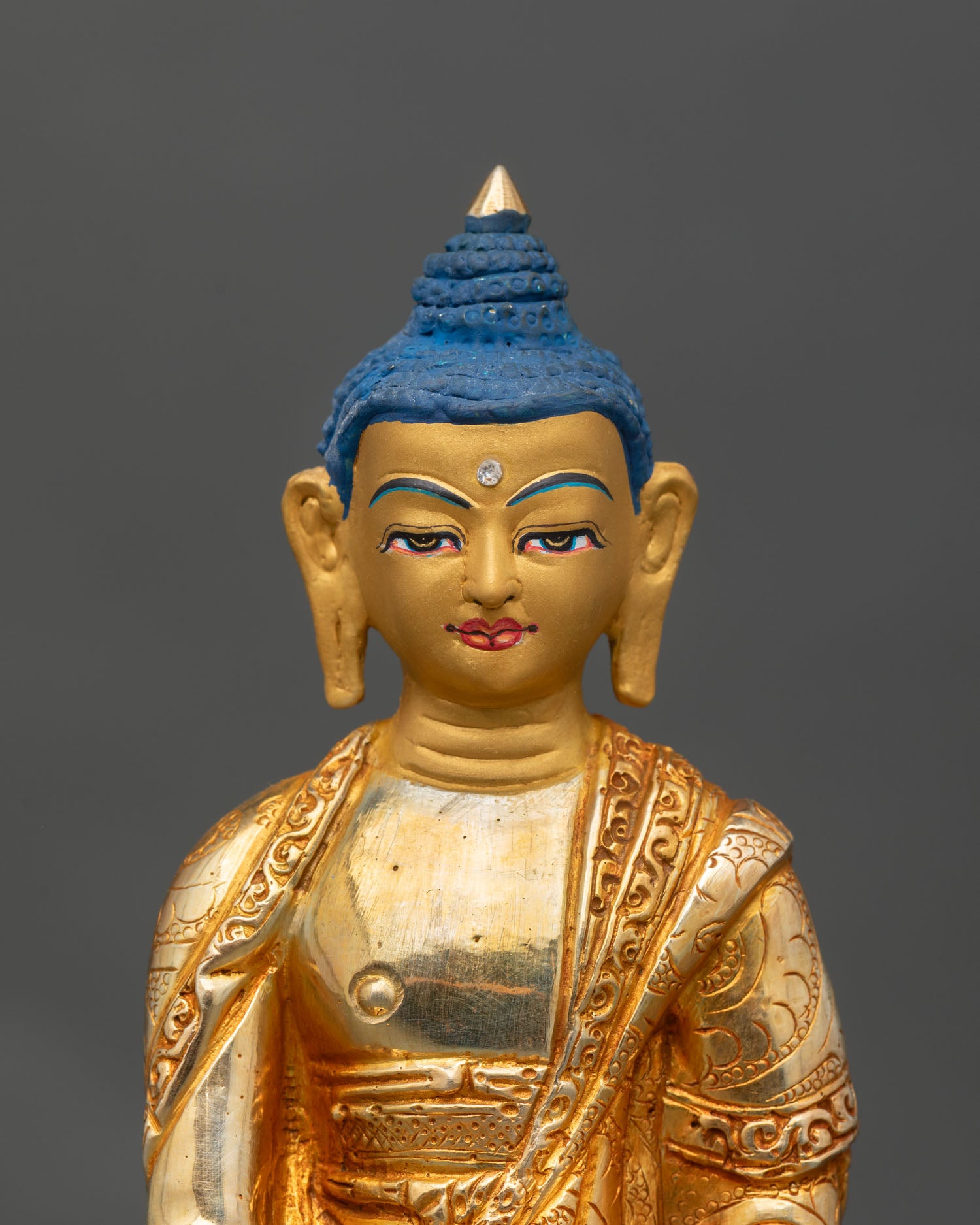 Close up Shakyamuni Buddha gold painted face copper statue Newari art lost wax casting detail