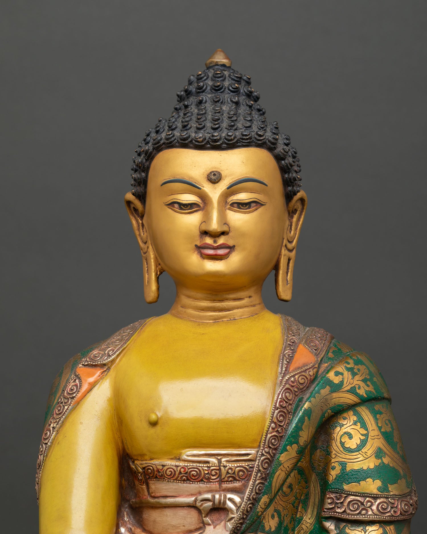 Close up Shakyamuni Buddha serene gold painted face with vibrant acrylic colors
