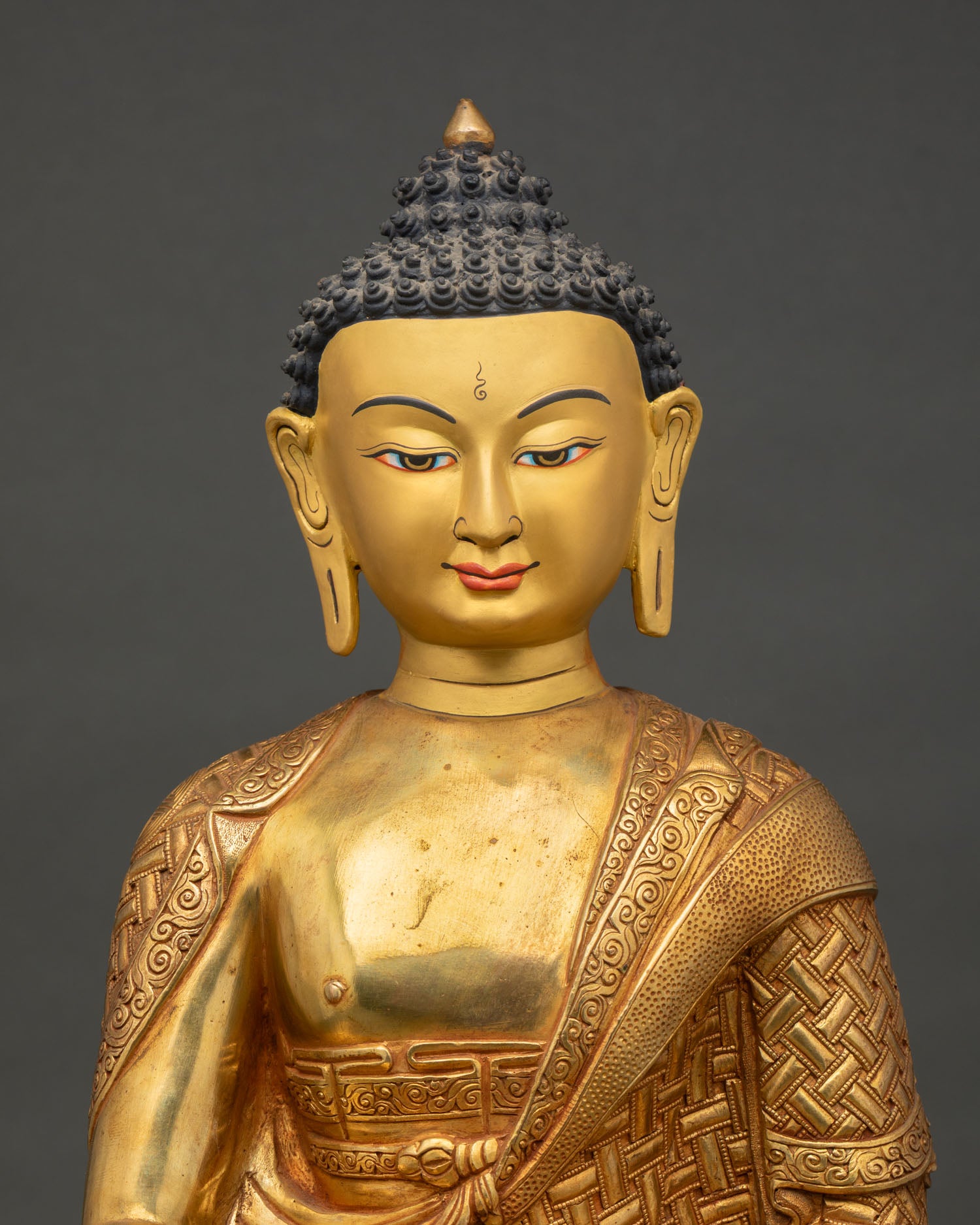 close up shakyamuni buddha statue gold painted face and detailed craftsmanship