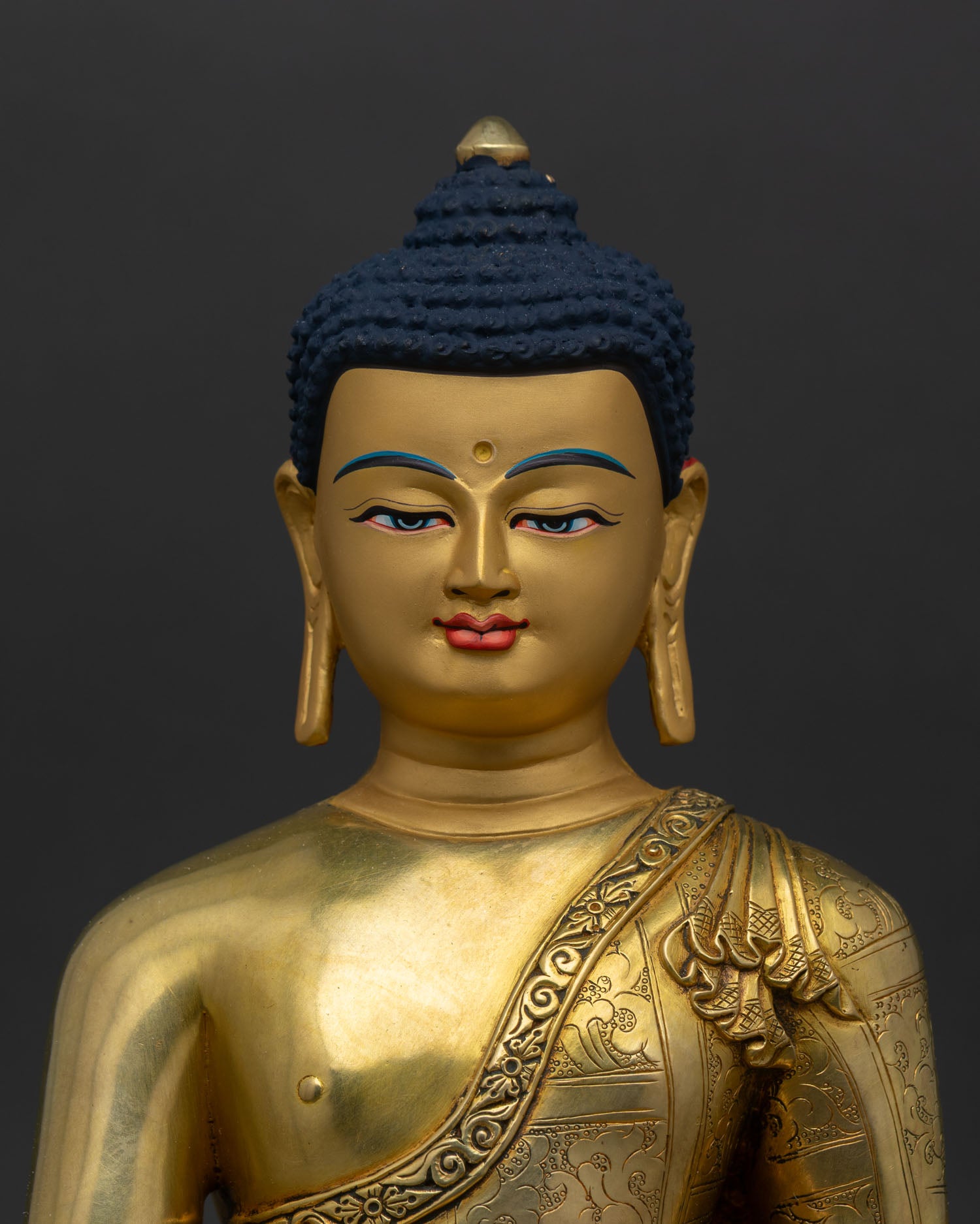 Close up Shakyamuni Buddha statue gold painted face detailed eyes handcrafted Nepal craftsmanship