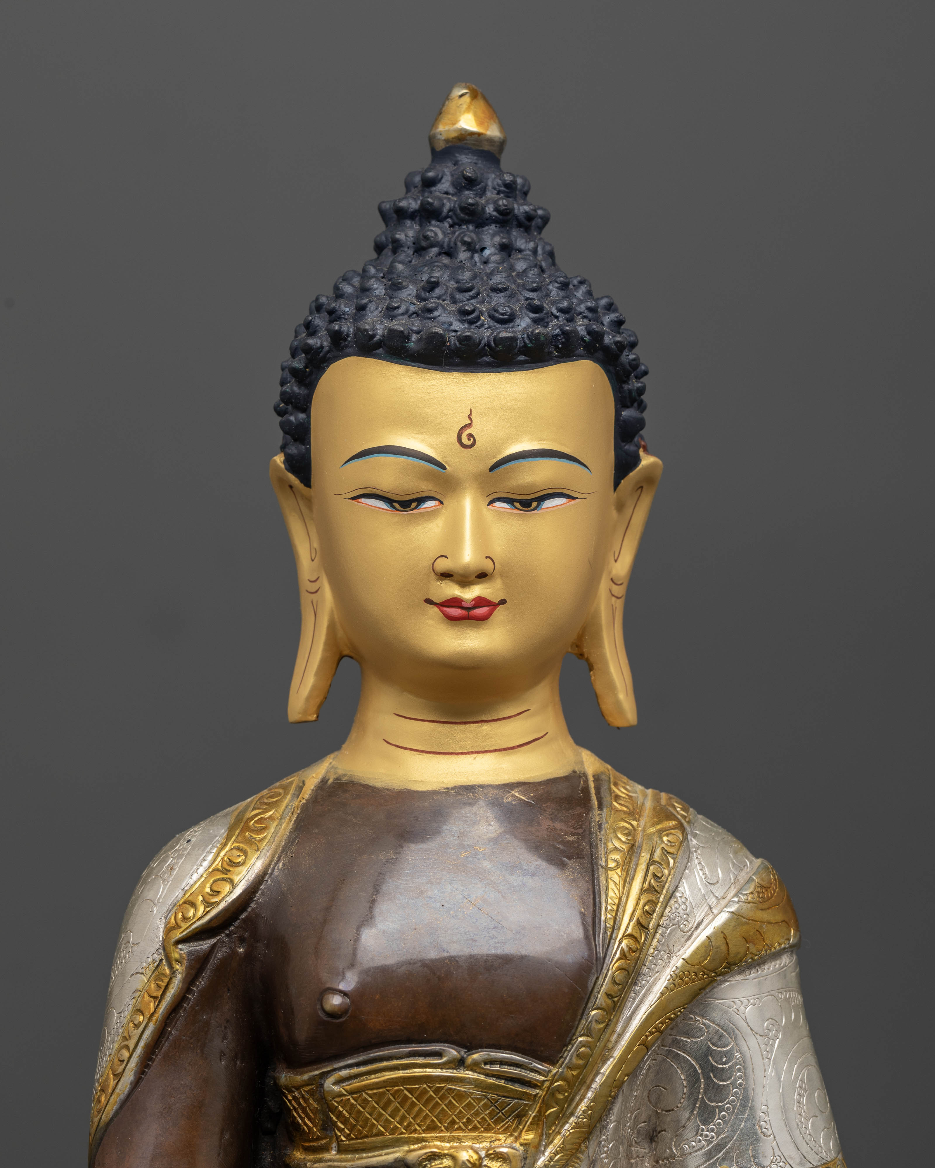 Close up of Shakyamuni Buddha with oxidized copper and gold-painted facial details