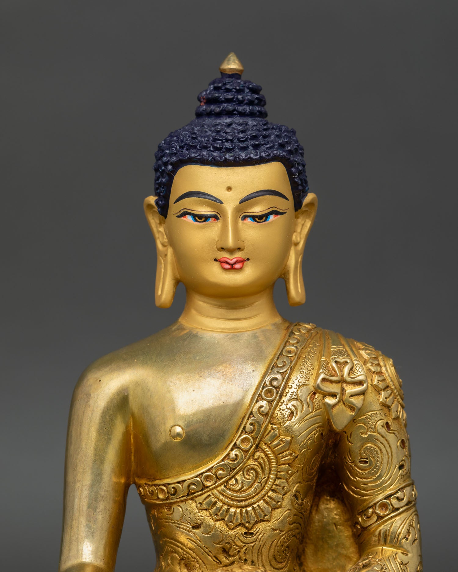 Close up Shakyamuni Buddha statue with gold painted face and serene expression