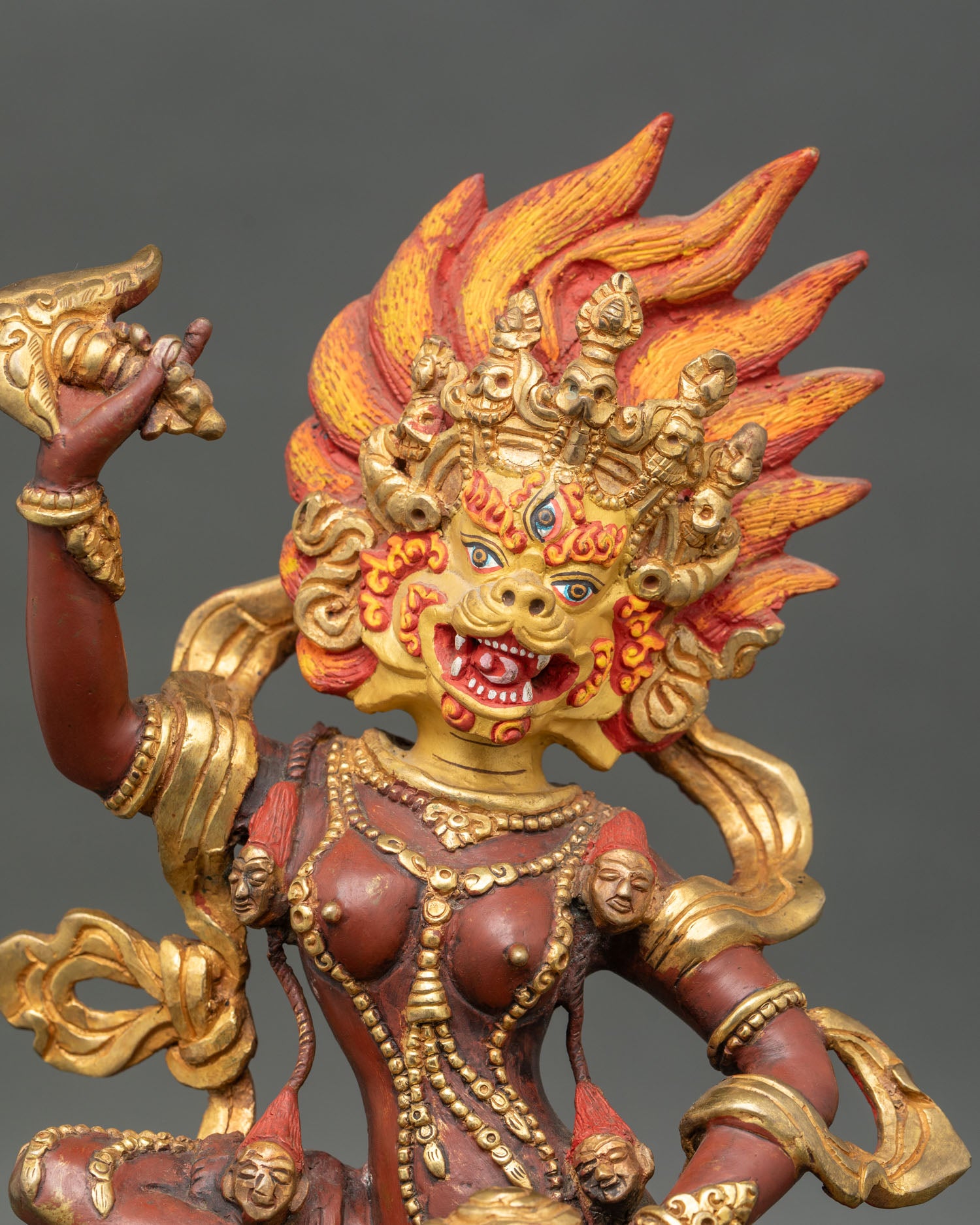 Close up of Simha Mukha face, third eye gold-painted face, crown lotus seat, Himalayan protector