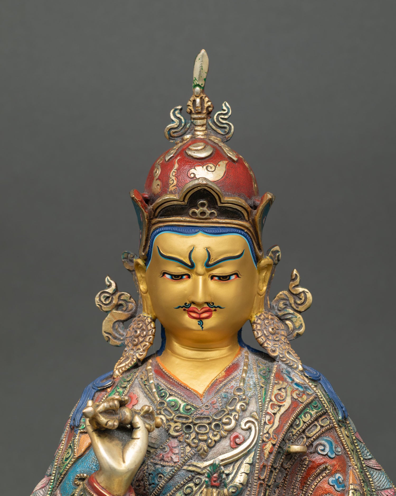 Close up of Tsokye Dorje sculpture, gold face, vajra at heart, skull cup, symbolism, serene expression, detail