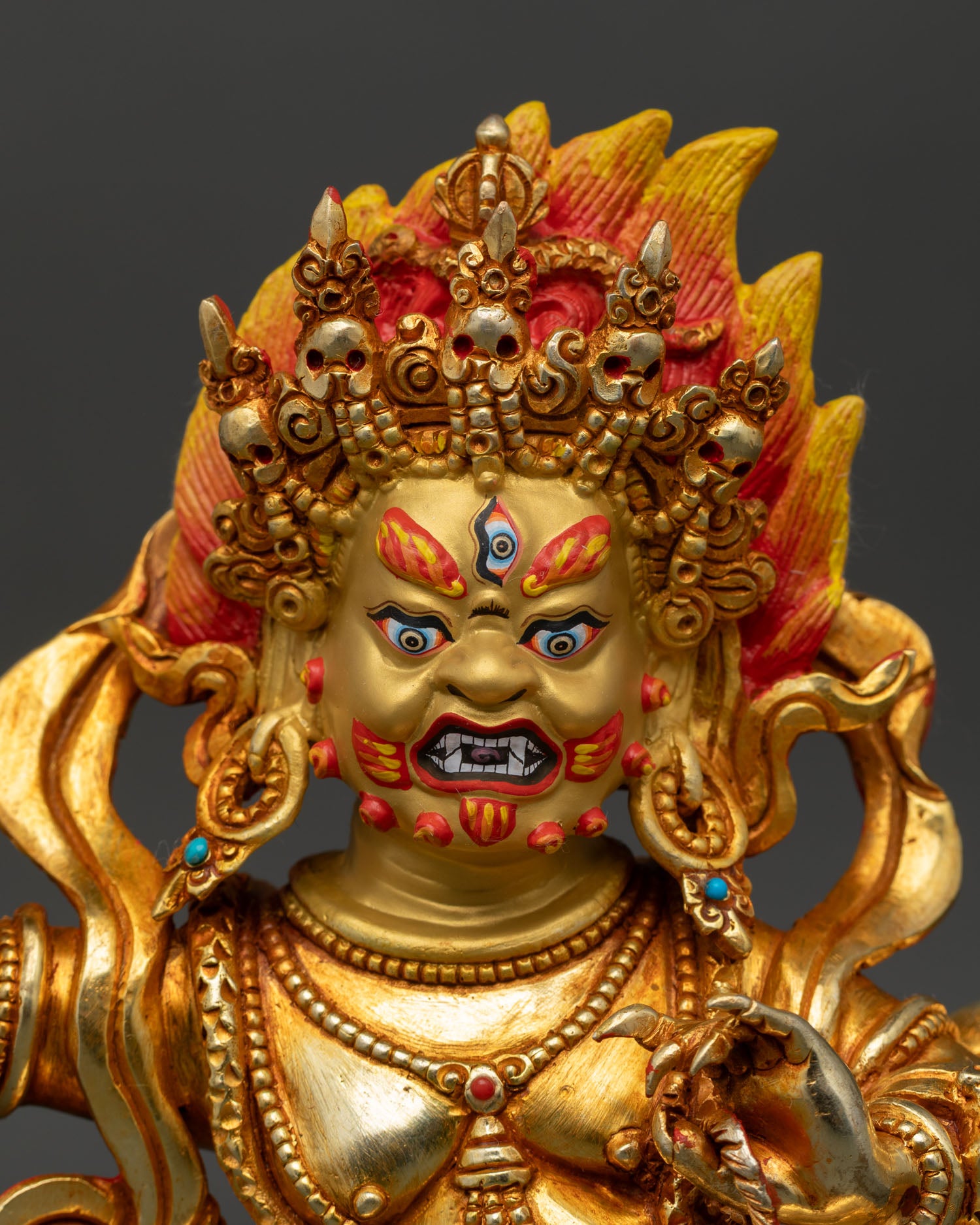 close up vajrapani face detail flaming hair vajra weapon gold painted expression buddhist protector deity statue