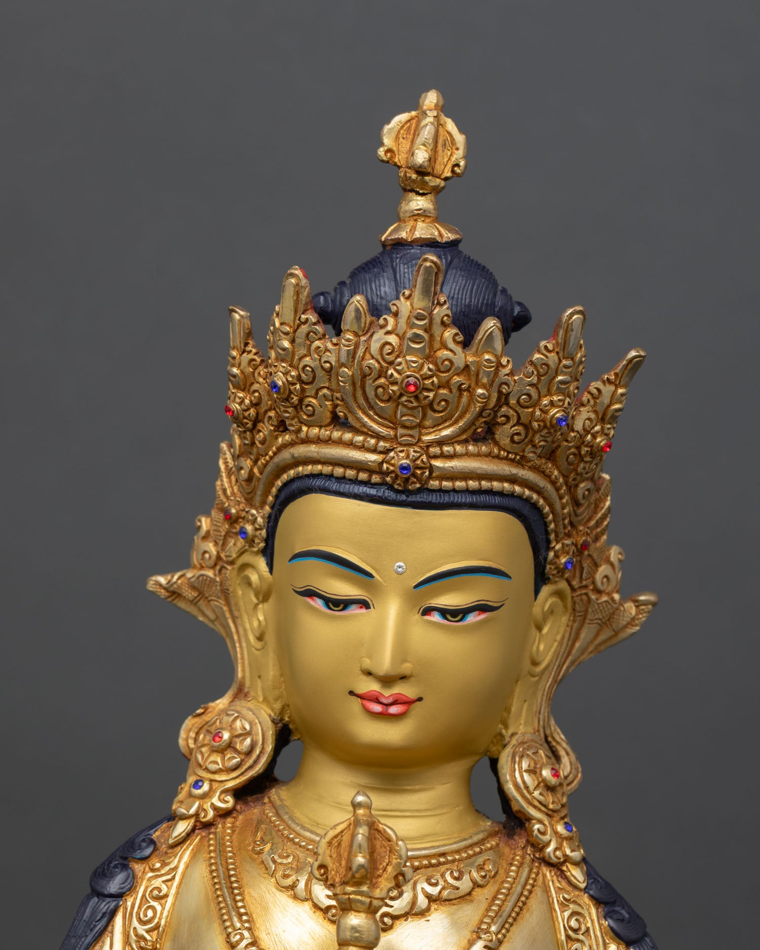 close up vajrasattva face detail gold painted serene expression semi precious stones vajra bell buddhist art
