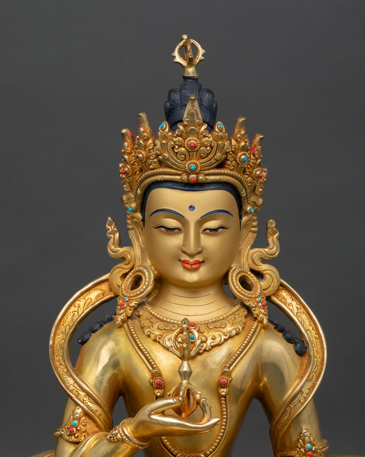 Close up Vajrasattva gold painted face, holding vajra, Tibetan Buddhist purification and meditation art