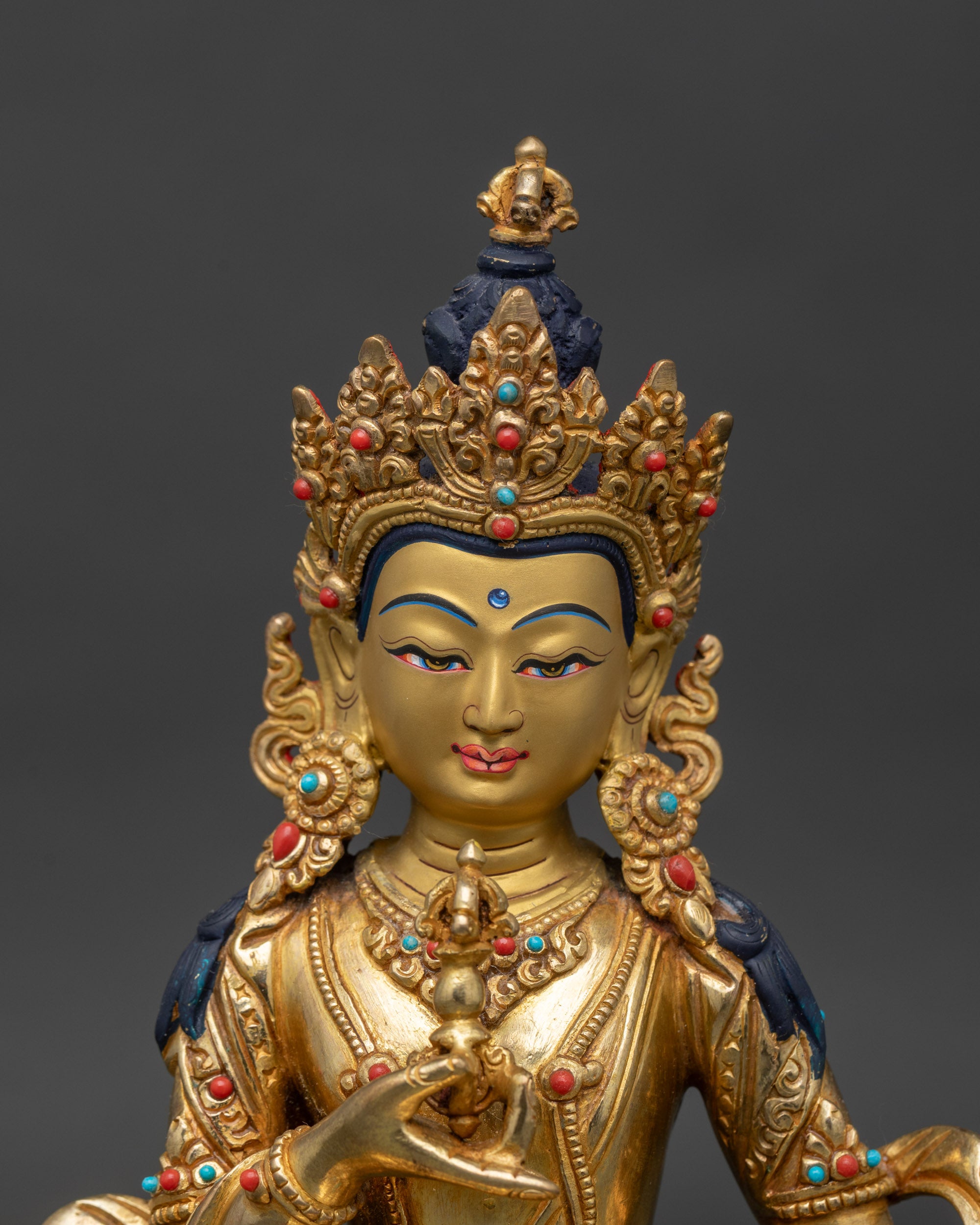 Close up Vajrasattva sacred figure intricately carved robes precious stones spiritual practice