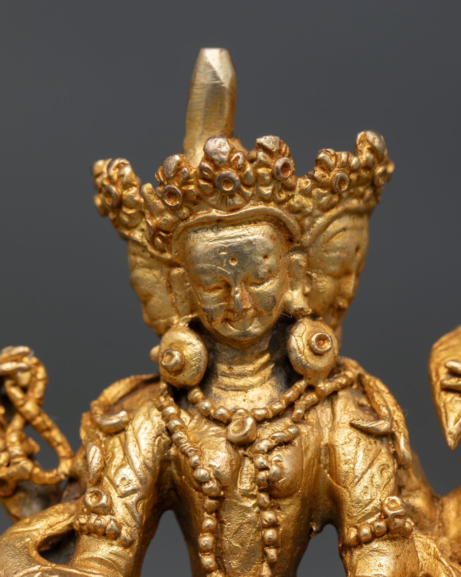 Close up Vasudhara statue sacred manuscript treasure vase grain symbolism Himalayan Buddhist prosperity deity art Nepal