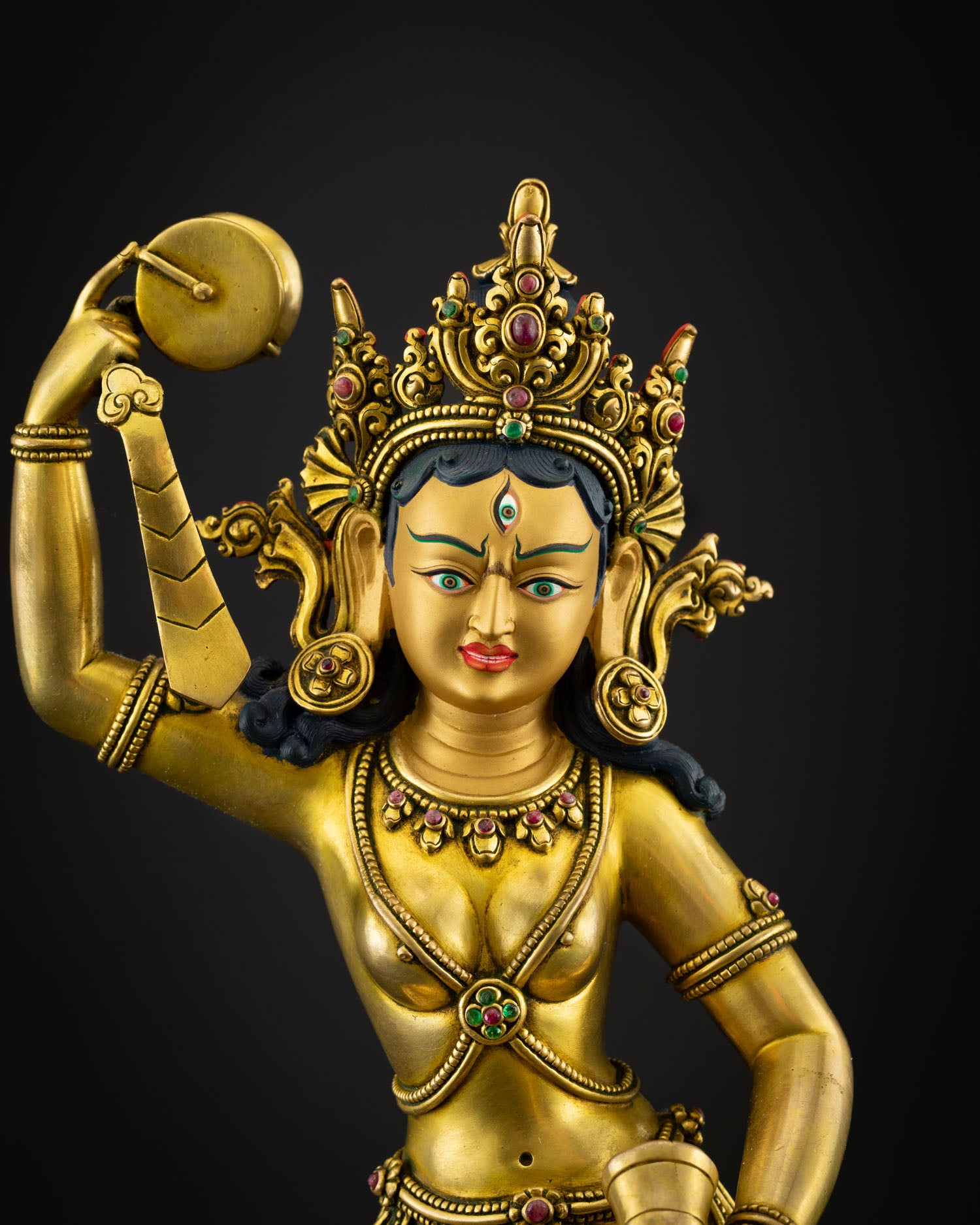 Close up view Machig Labdron face with gold painted expression intricate crown and sacred jewelry symbolizing compassion wisdom and enlightened feminine energy
