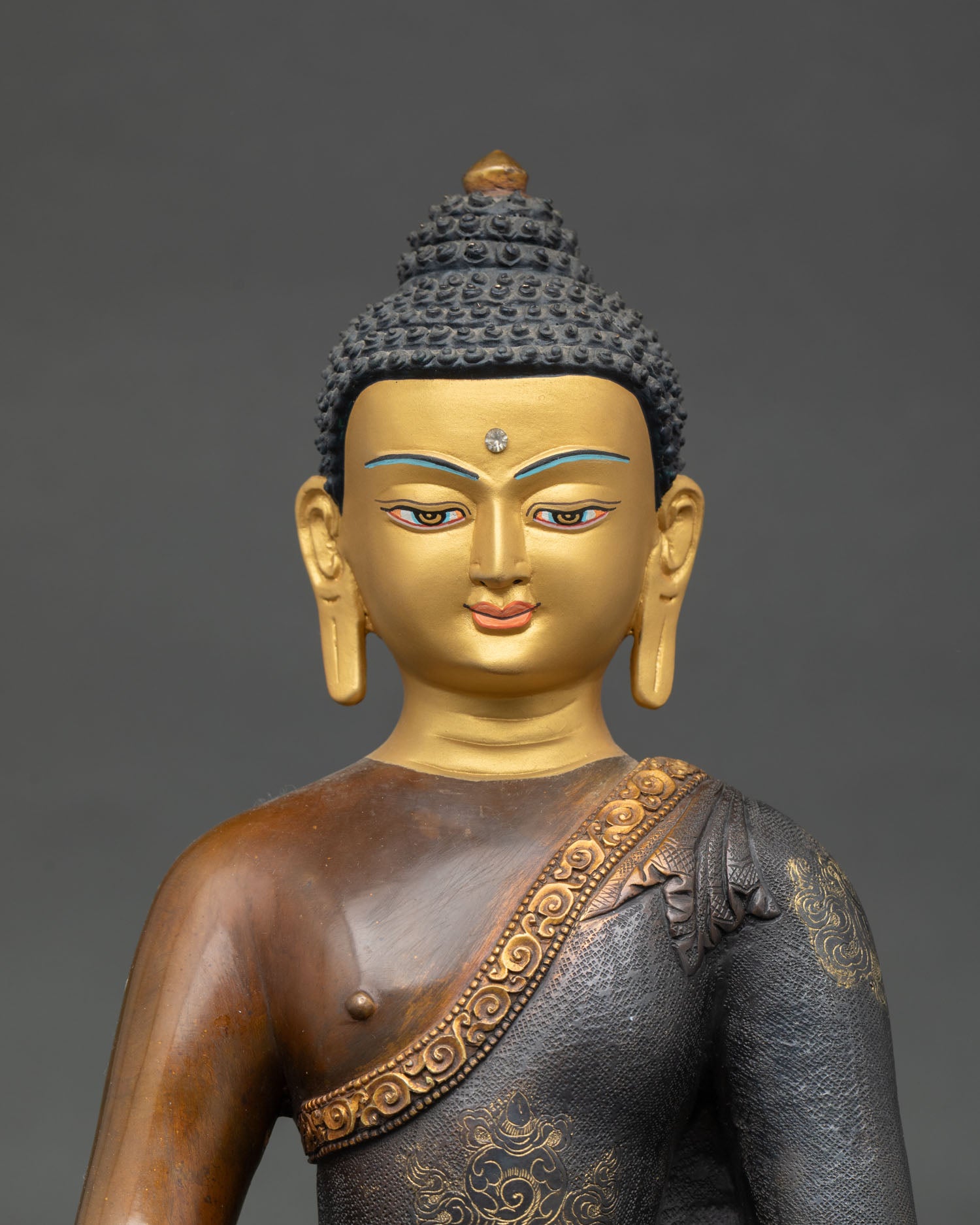 Close up view of Amitabha Buddha sculpture showing serene gold painted face monastic robe details and traditional Himalayan craftsmanship